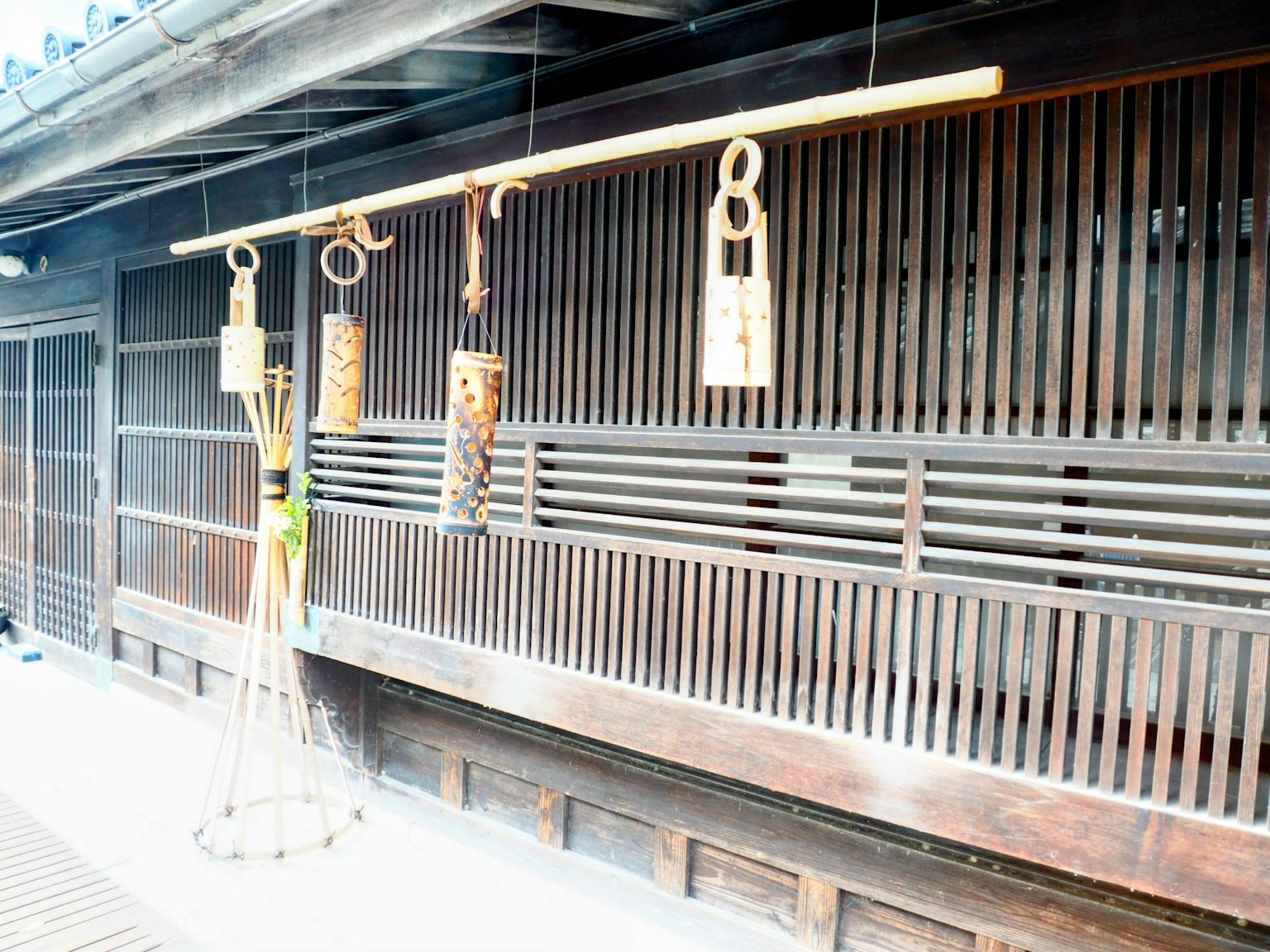 Exterior de un edificio japonés tradicional con campanas de viento de bambú colgantes y decoraciones