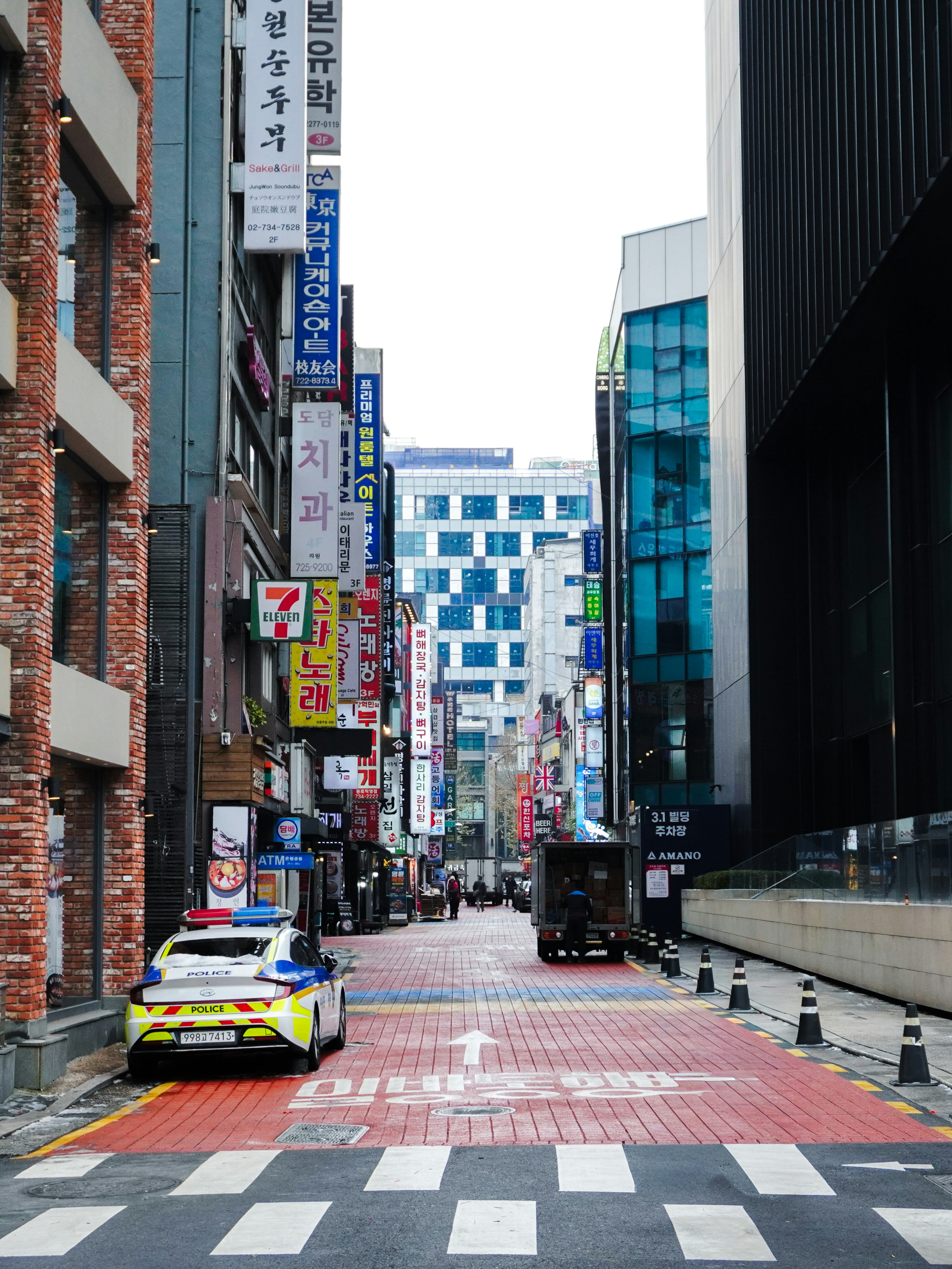 路地に並ぶ看板とタクシーのある都市の通り