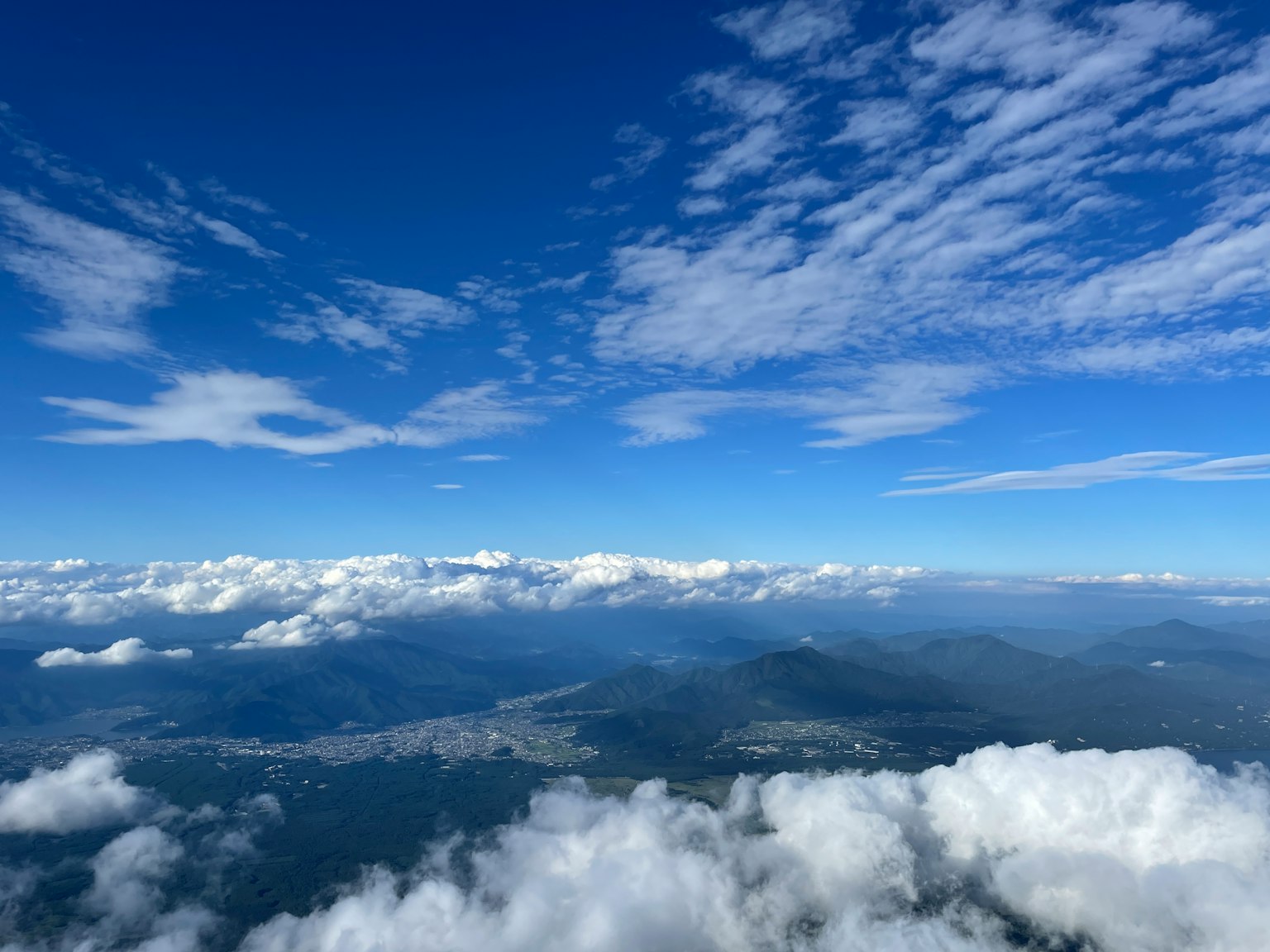 Ampio cielo blu con nuvole bianche che sovrastano le montagne