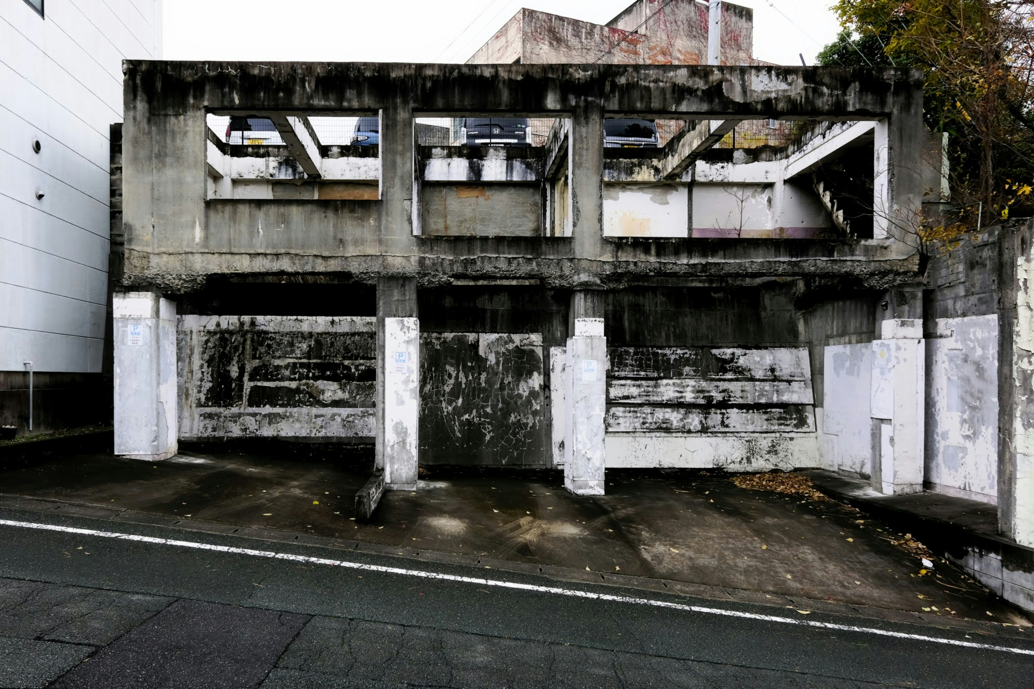 老朽化した立体駐車場の外壁と白い支柱
