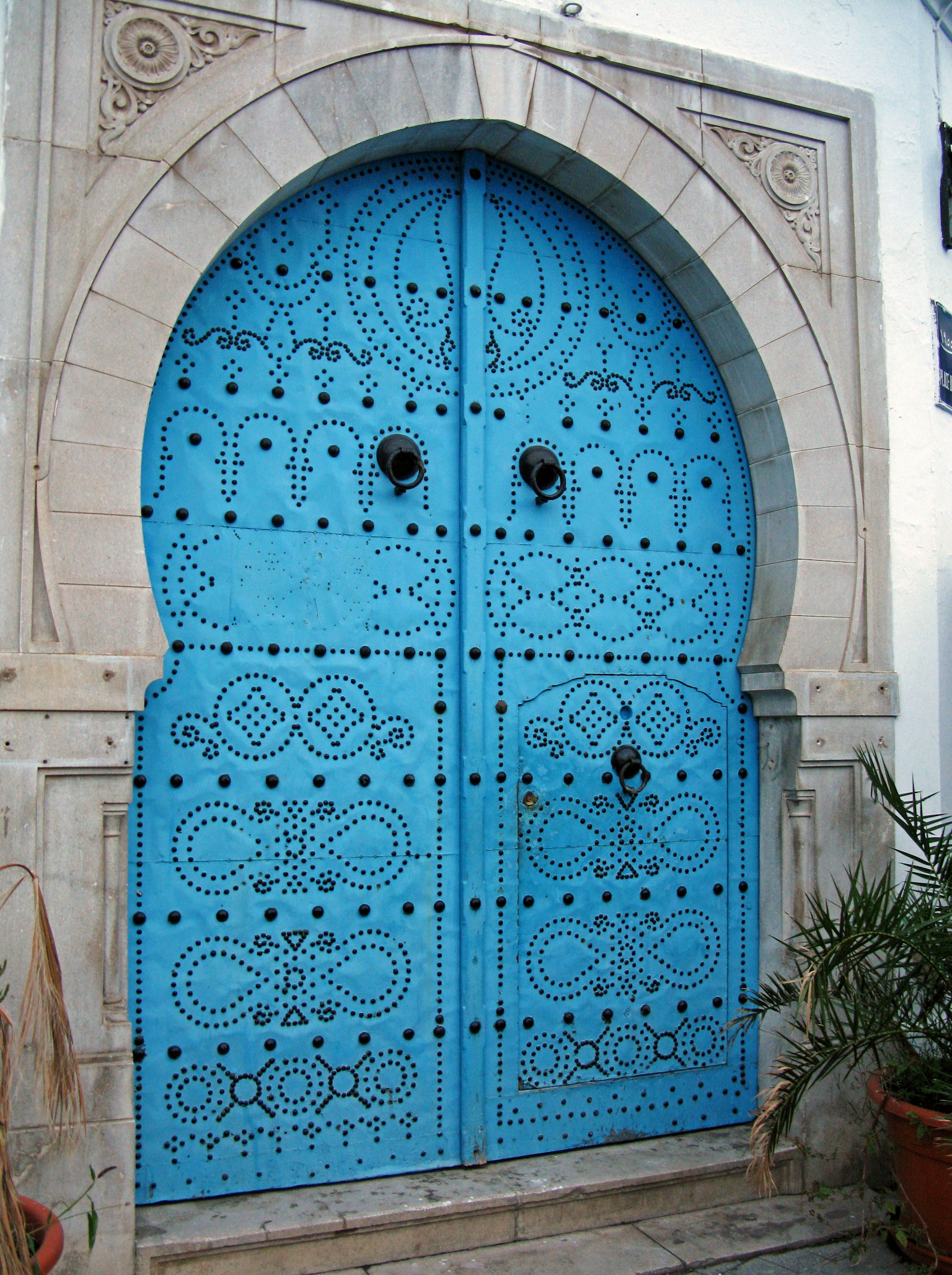 Porte bleue décorative avec des motifs complexes et une entrée en arc