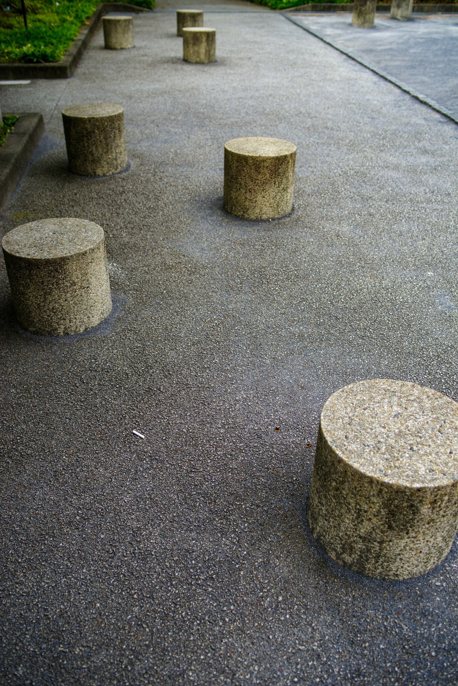 Concrete cylindrical benches arranged on a park pavement