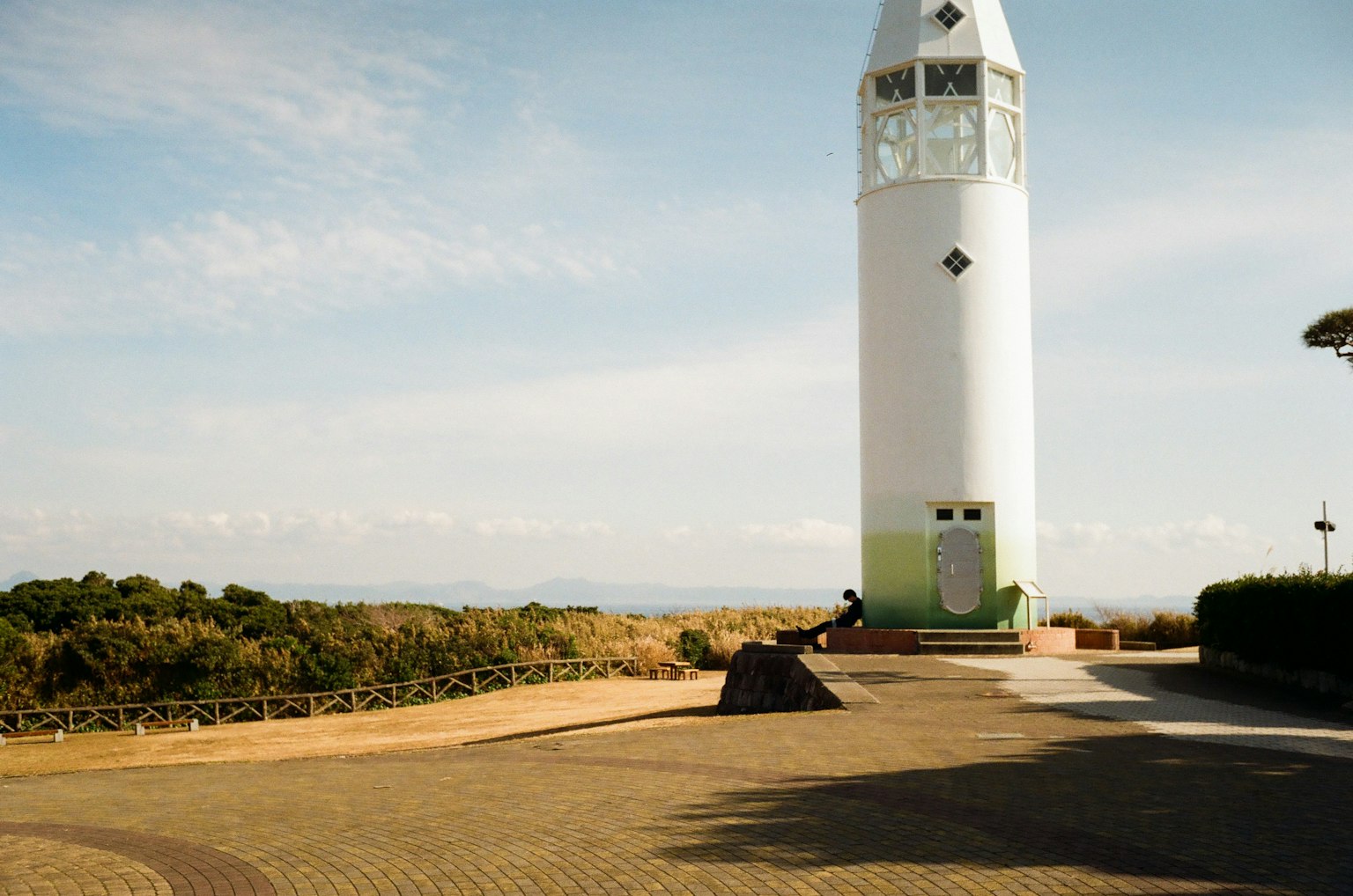 Vue d'un phare blanc dans un parc spacieux