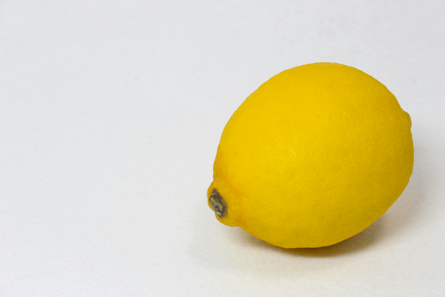 Un limone giallo brillante su uno sfondo bianco