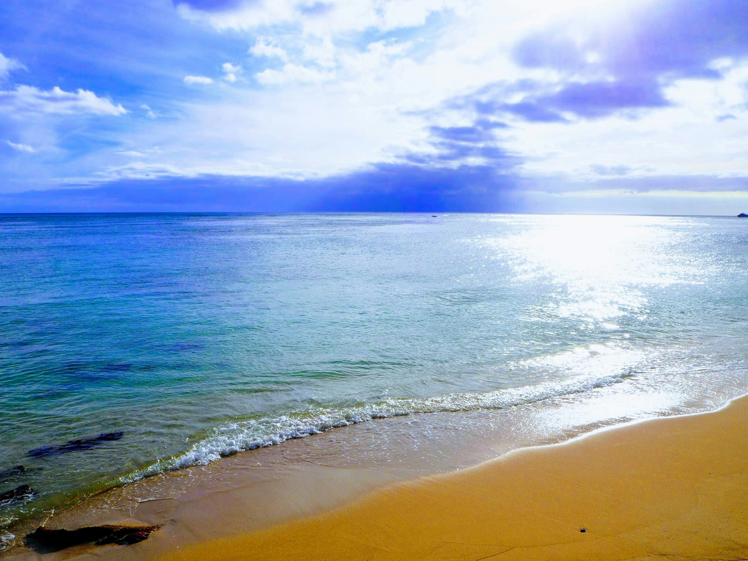 ทิวทัศน์ชายหาดที่สวยงามมีมหาสมุทรและท้องฟ้าสีฟ้า