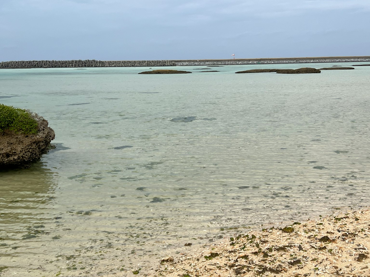 Mare calmo con acque poco profonde spiaggia rocciosa e sabbiosa