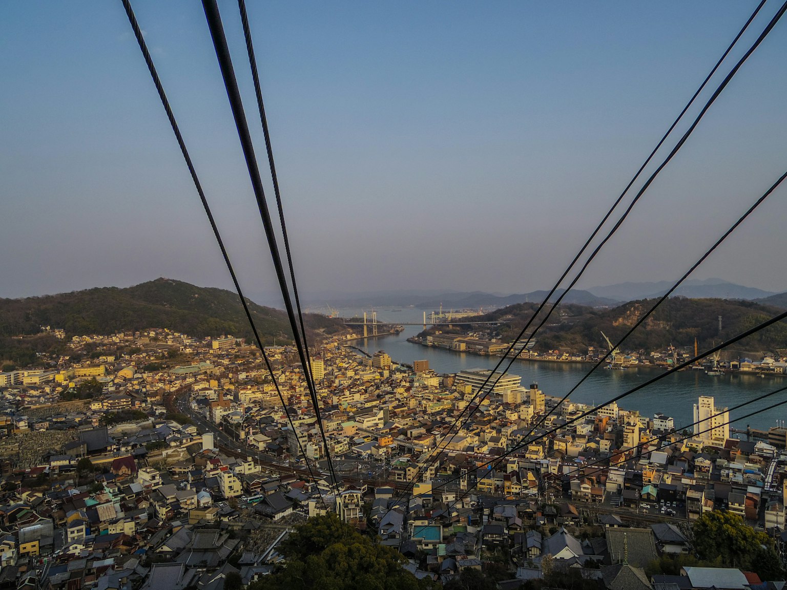 山の上からの美しい都市景観と海の眺めケーブルカーのワイヤーが映る