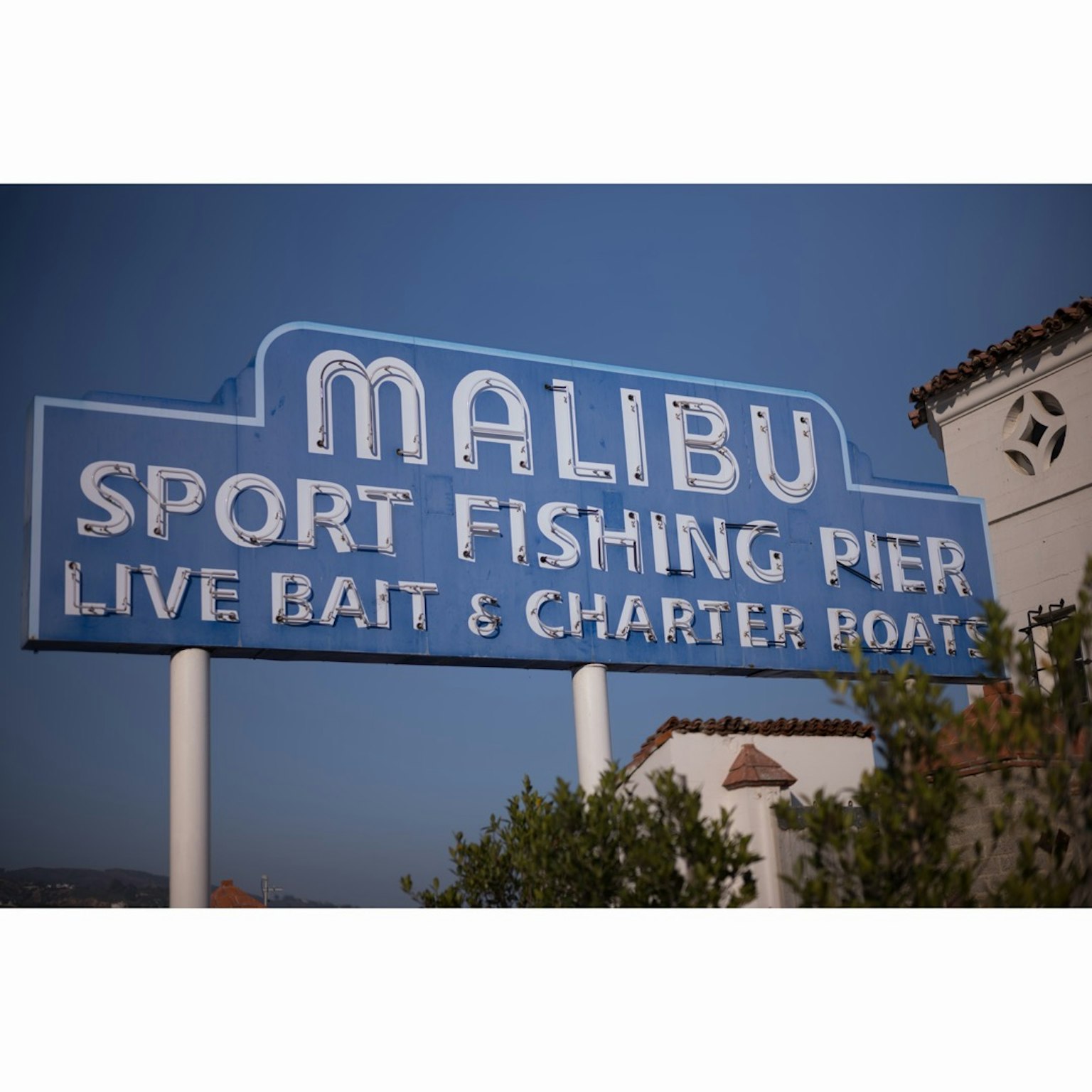 Biển hiệu màu xanh của Malibu Sport Fishing Pier nhấn mạnh mồi sống và thuyền cho thuê