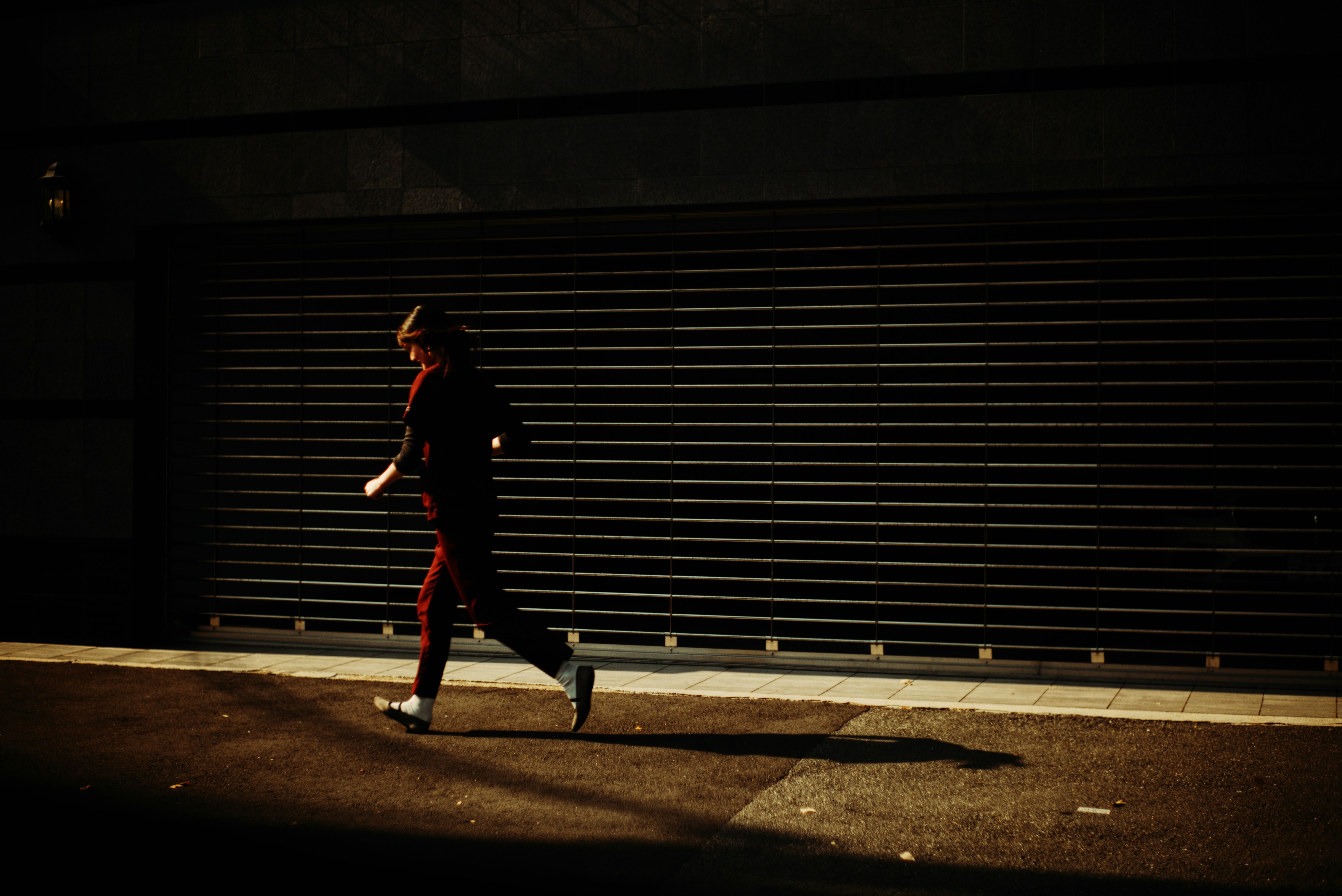 夕暮れの路地を歩く人物