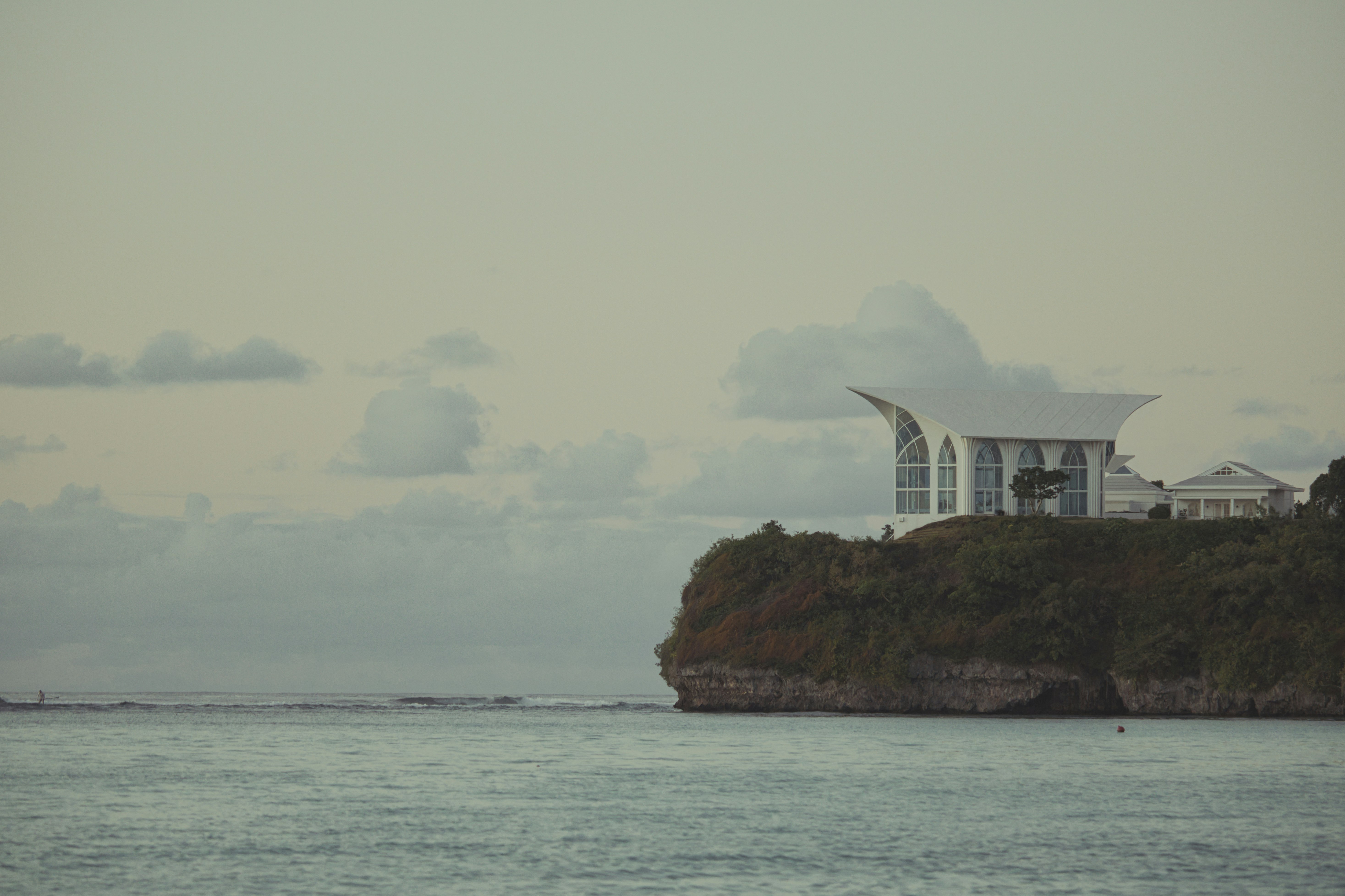 edificio bianco con cupola su una scogliera visto dal mare