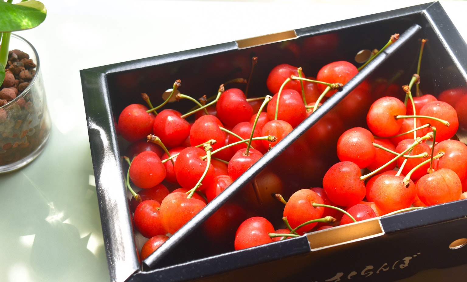 A box of red cherries placed on a table