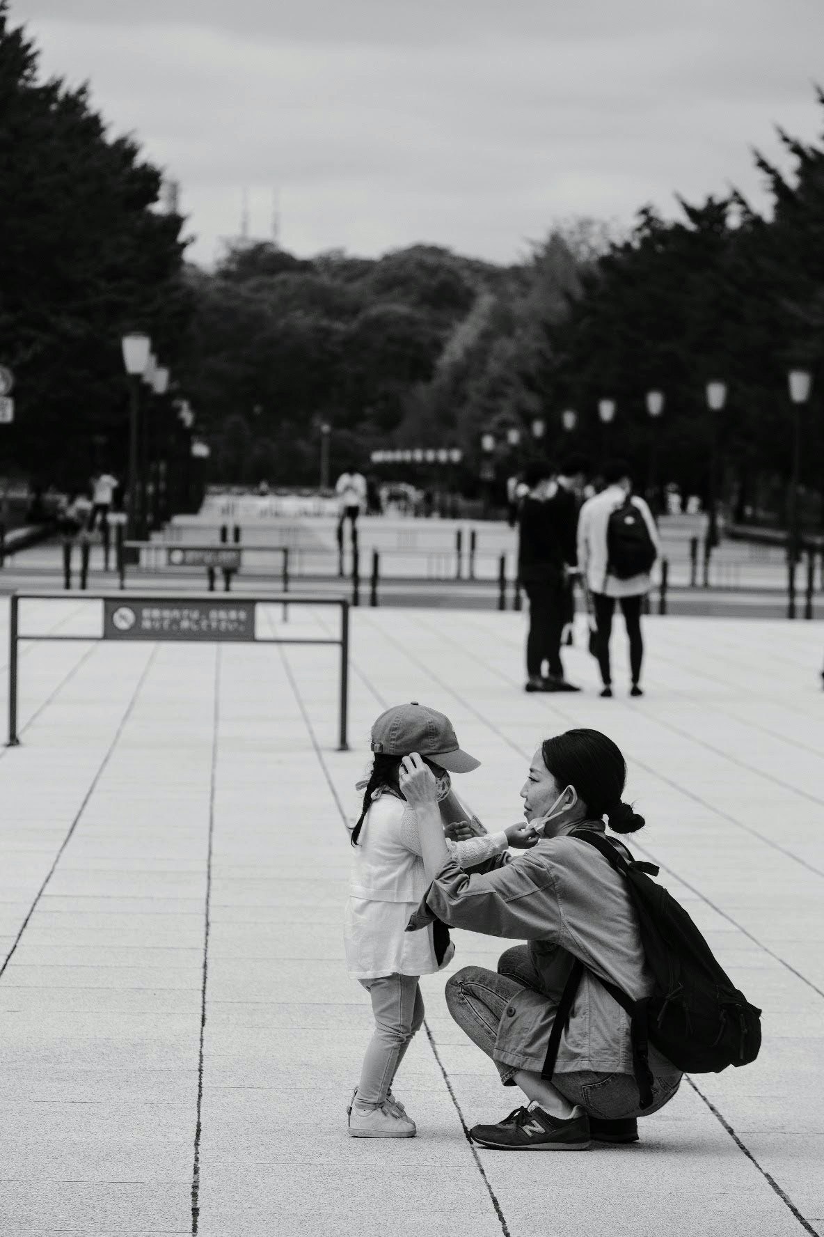 candid moment of a child and parent playing in a plaza