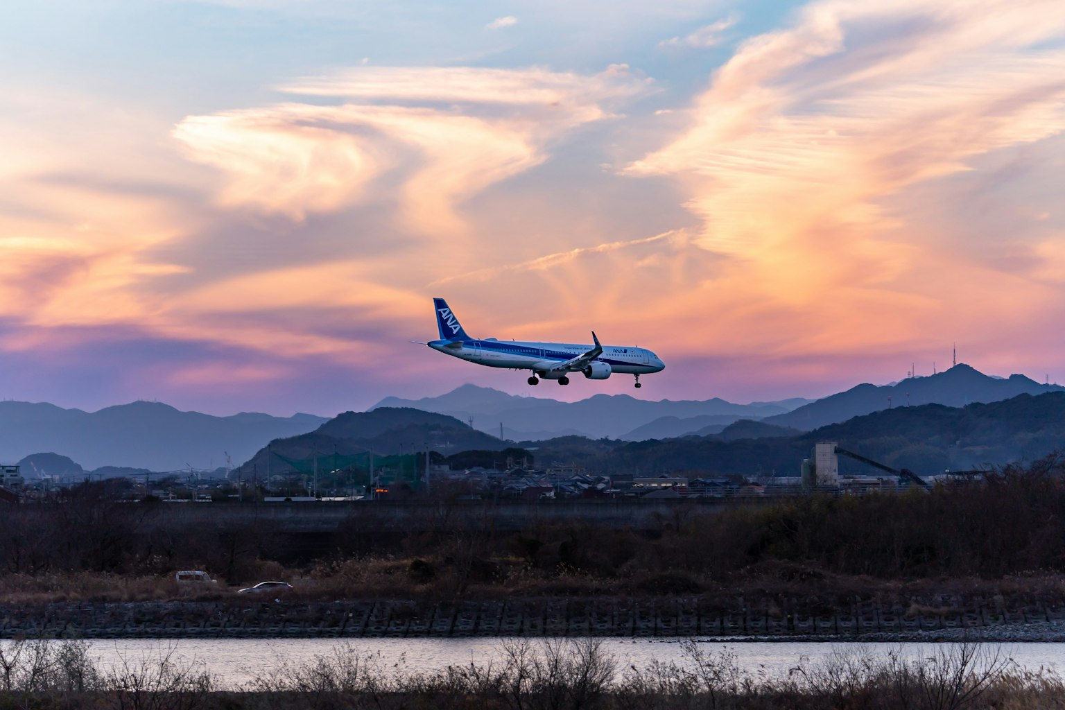 Un avion atterrissant contre un ciel au coucher du soleil