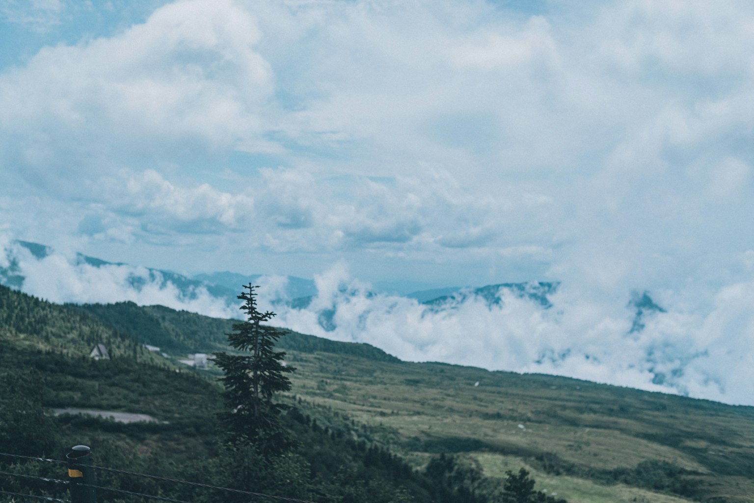 Vue pittoresque des montagnes verdoyantes sous un ciel bleu avec des nuages