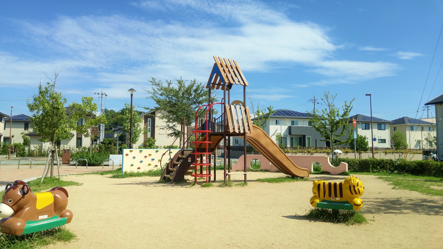 Scena luminosa di un parco giochi con struttura di arrampicata e scivolo