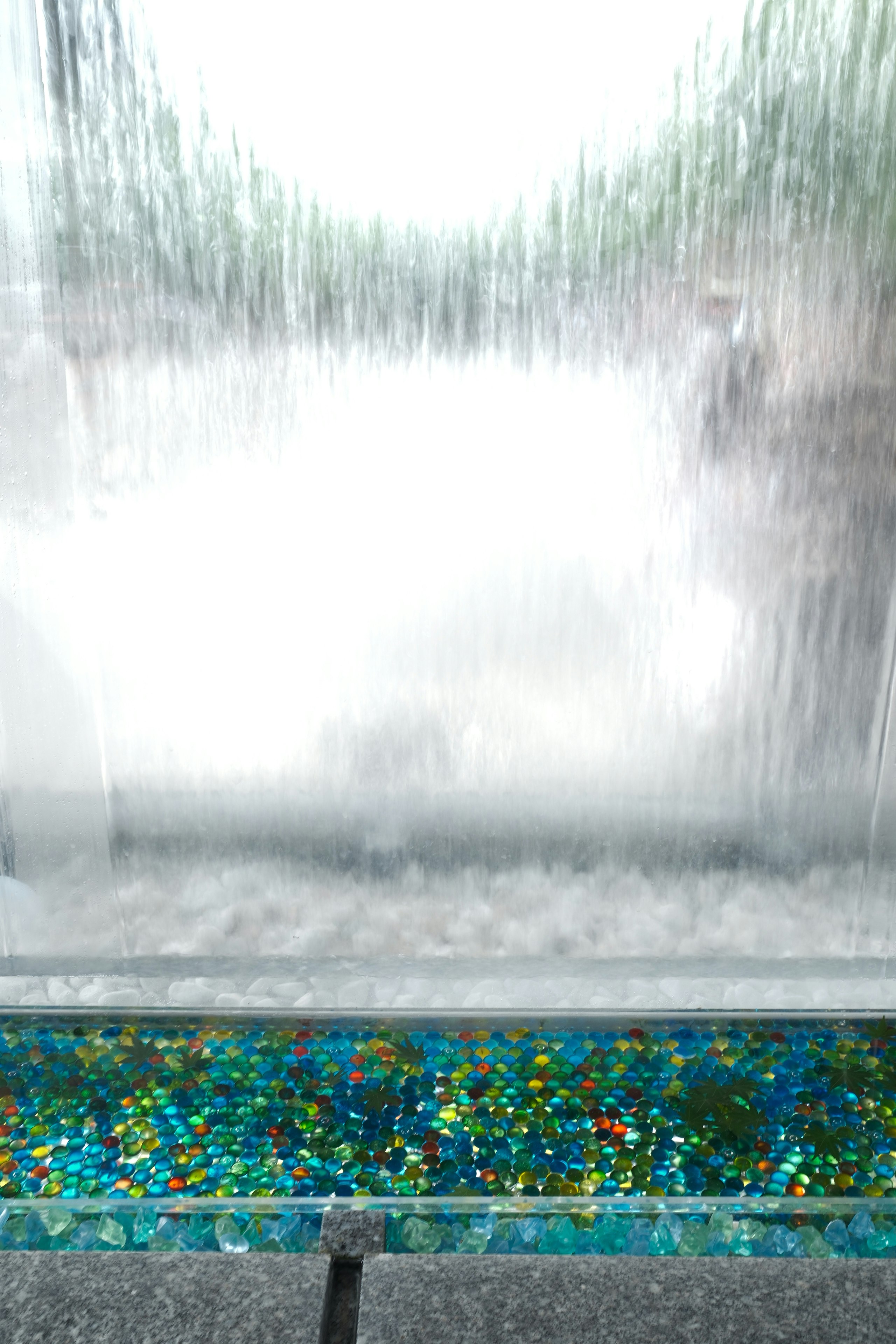 噴水の水しぶきと色鮮やかなモザイクの縁