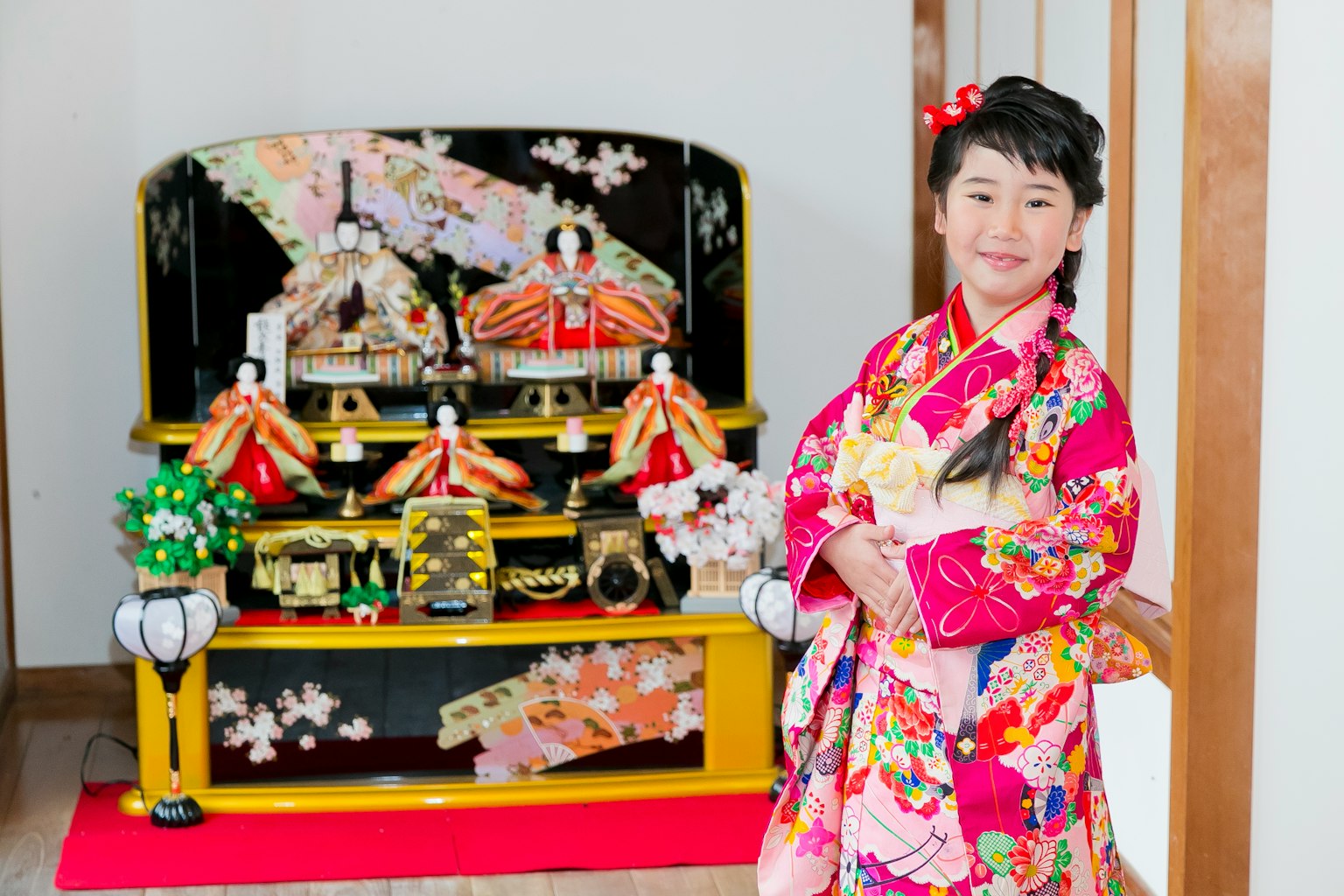 穿著色彩繽紛和服的女孩站在雛人偶展示前