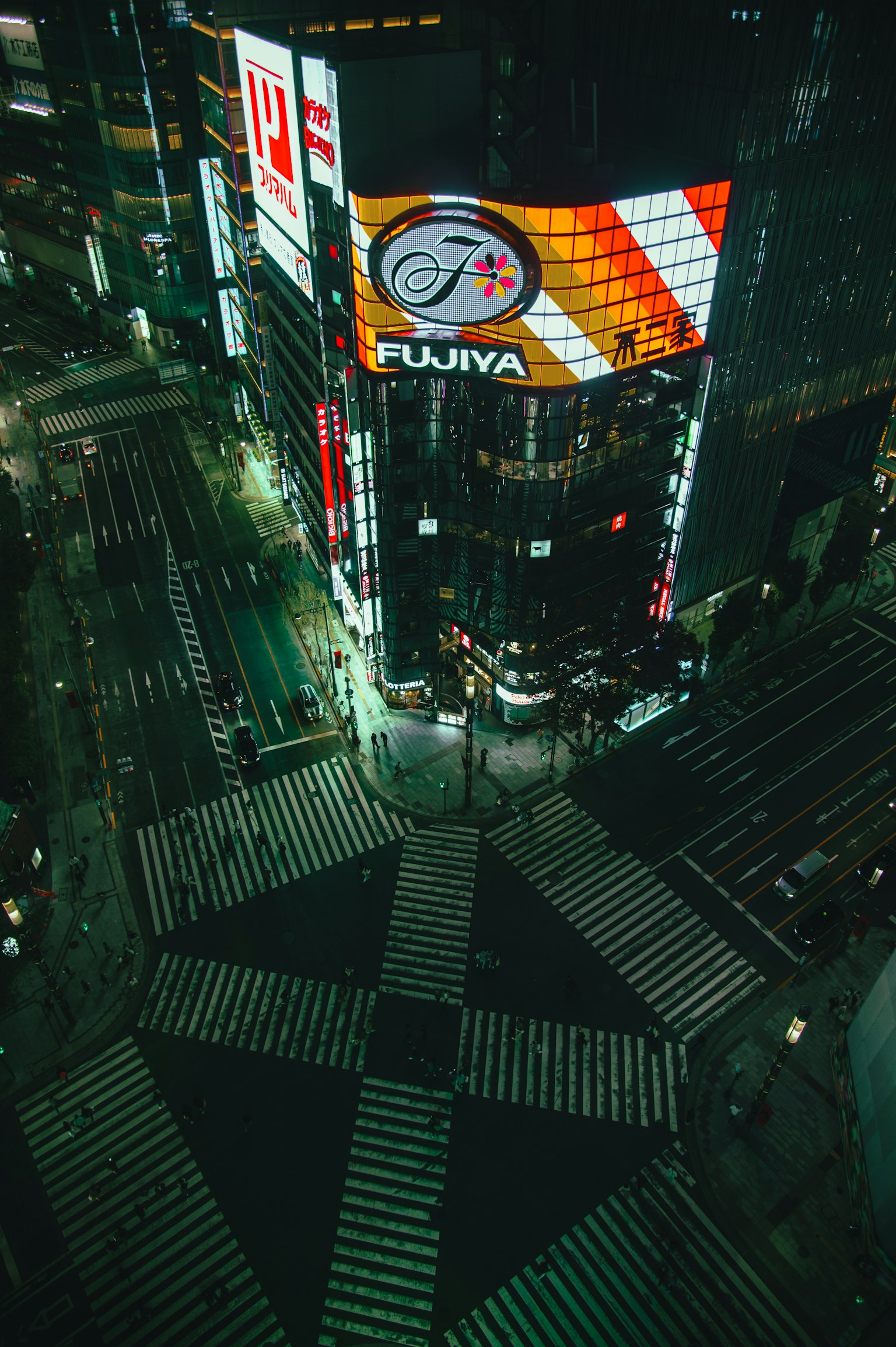 Nachtansicht einer Kreuzung in Tokio mit großem Billboard
