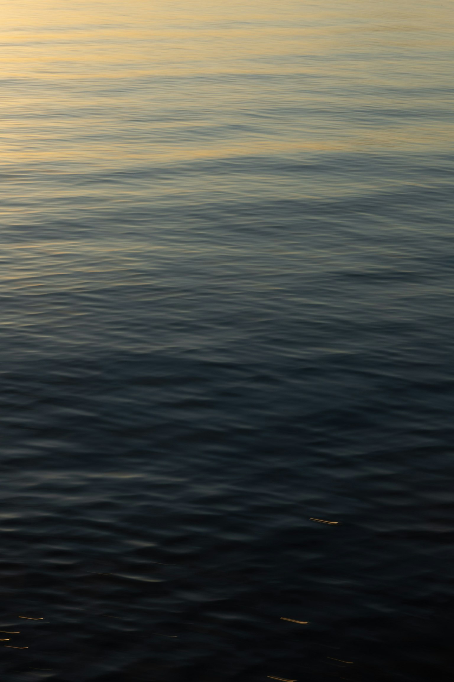 Superficie de agua tranquila con reflejos y ondas