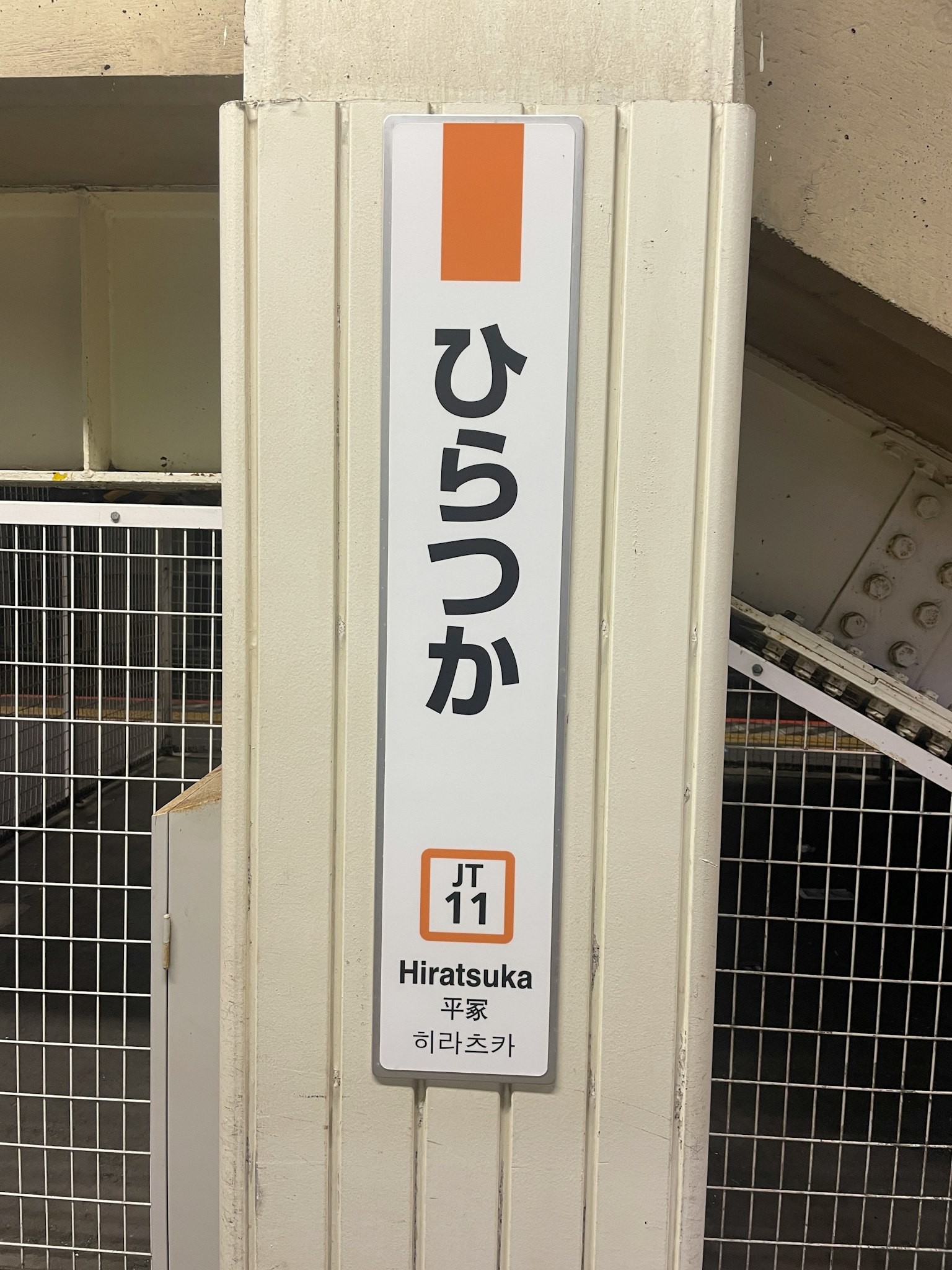 Schild der Station Hiratsuka auf einem weißen Pfeiler angezeigt