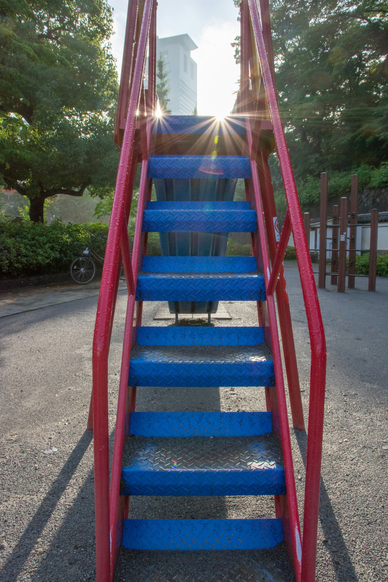 公園內紅色扶手的藍色樓梯和陽光