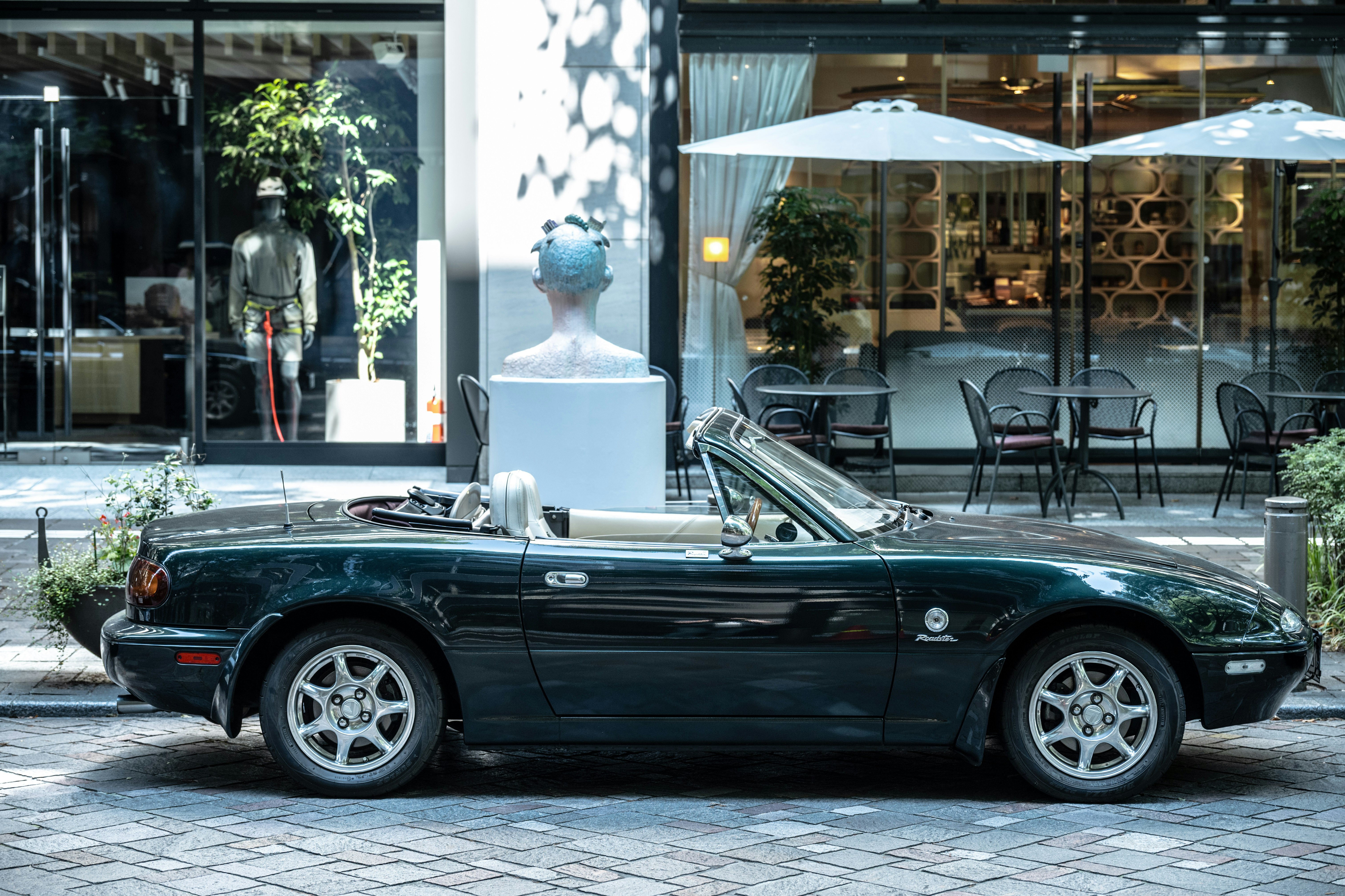 auto d’epoca parcheggiata in strada vicino a una terrazza di un caffè