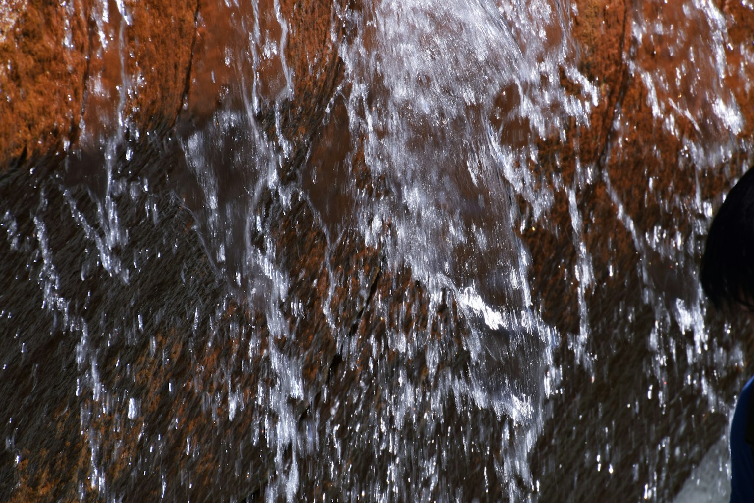 Eau s'écoulant sur une surface rocheuse créant un effet de fontaine naturelle