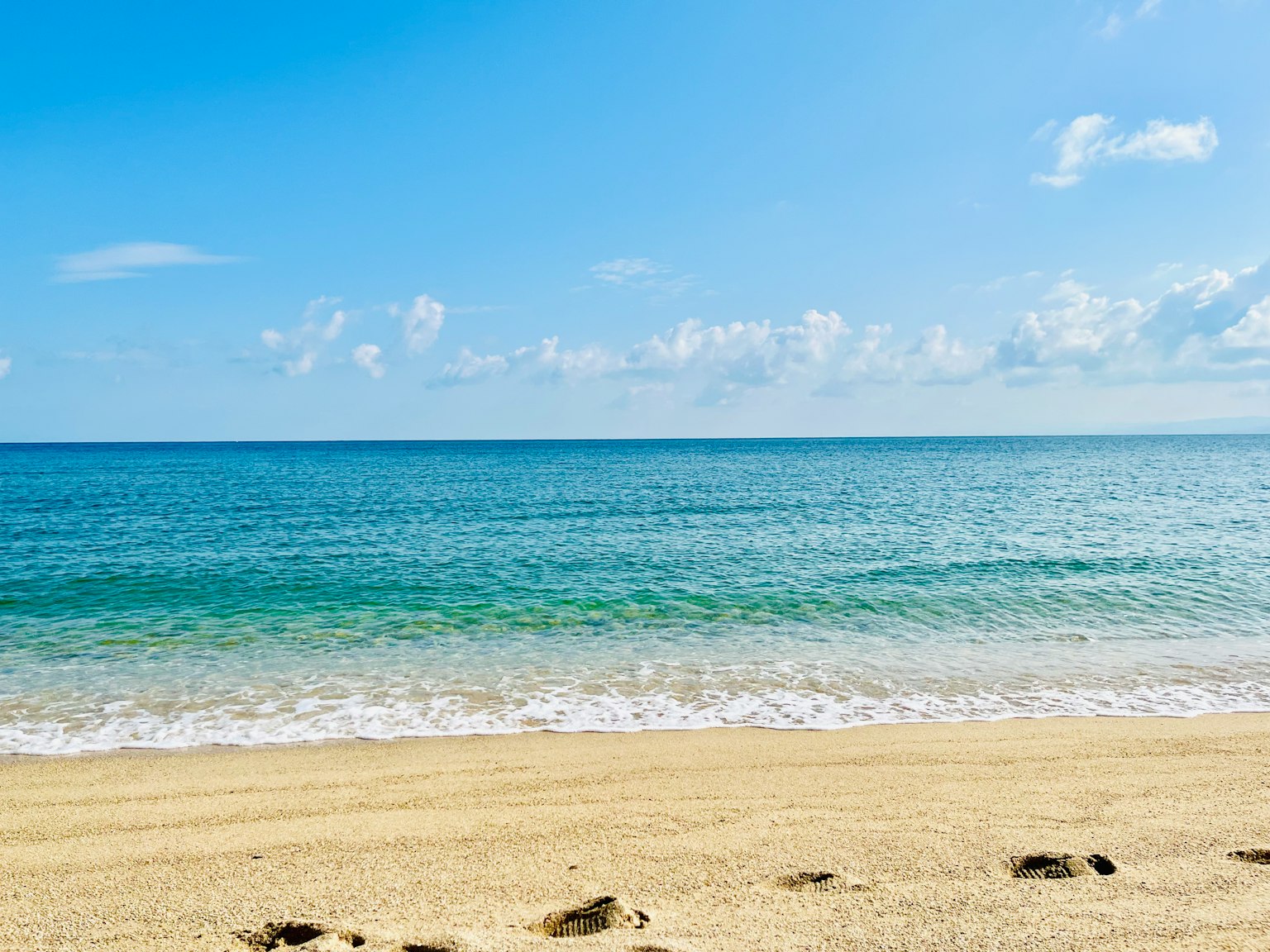 ทิวทัศน์ของทะเลสีน้ำเงินและชายหาดทราย