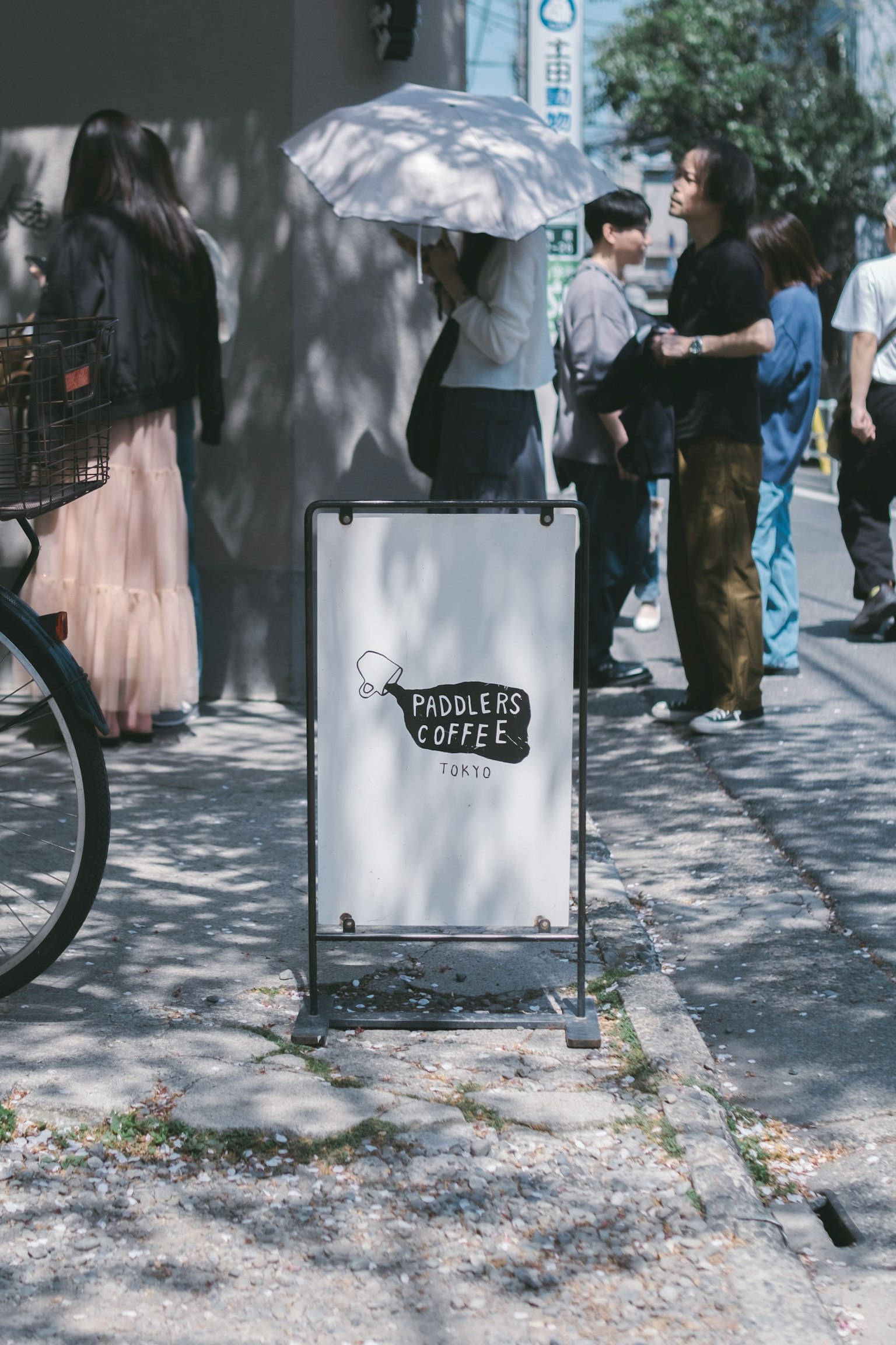 Coffee shop sign with people in an urban setting
