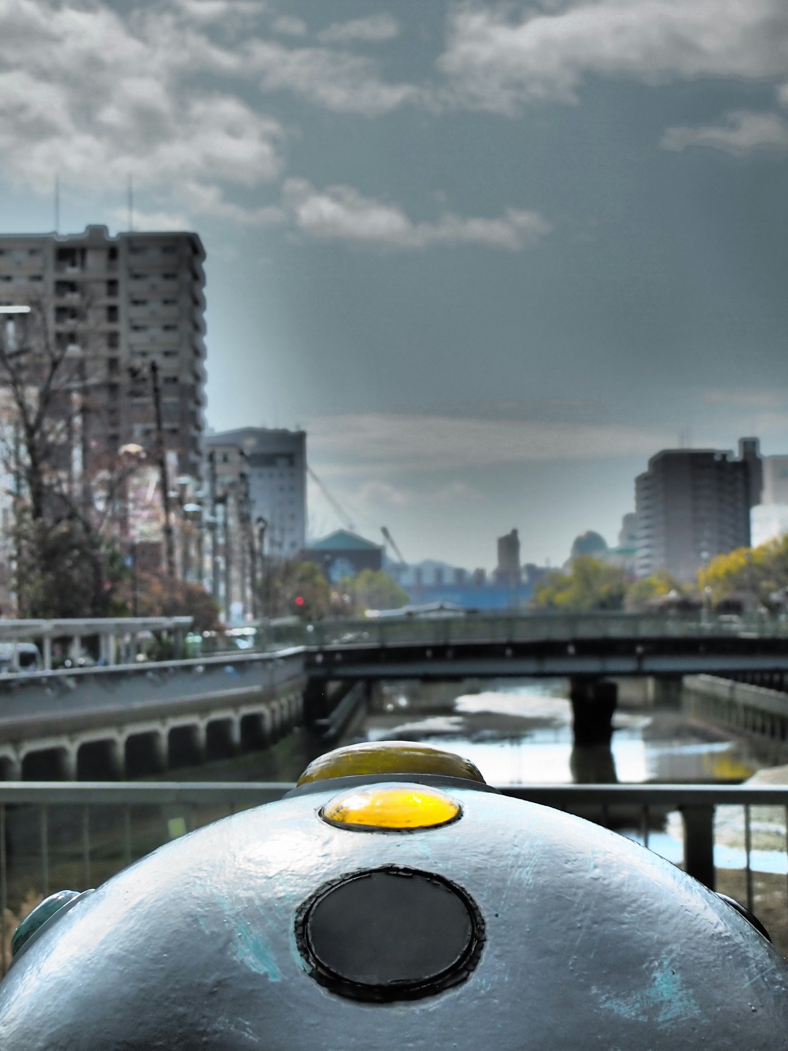 河流和城市景观背景下的圆形物体特写，带有黄色点
