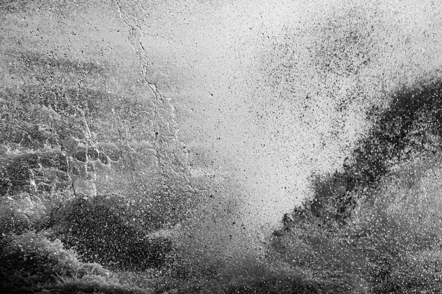 Black and white image of crashing waves and water spray