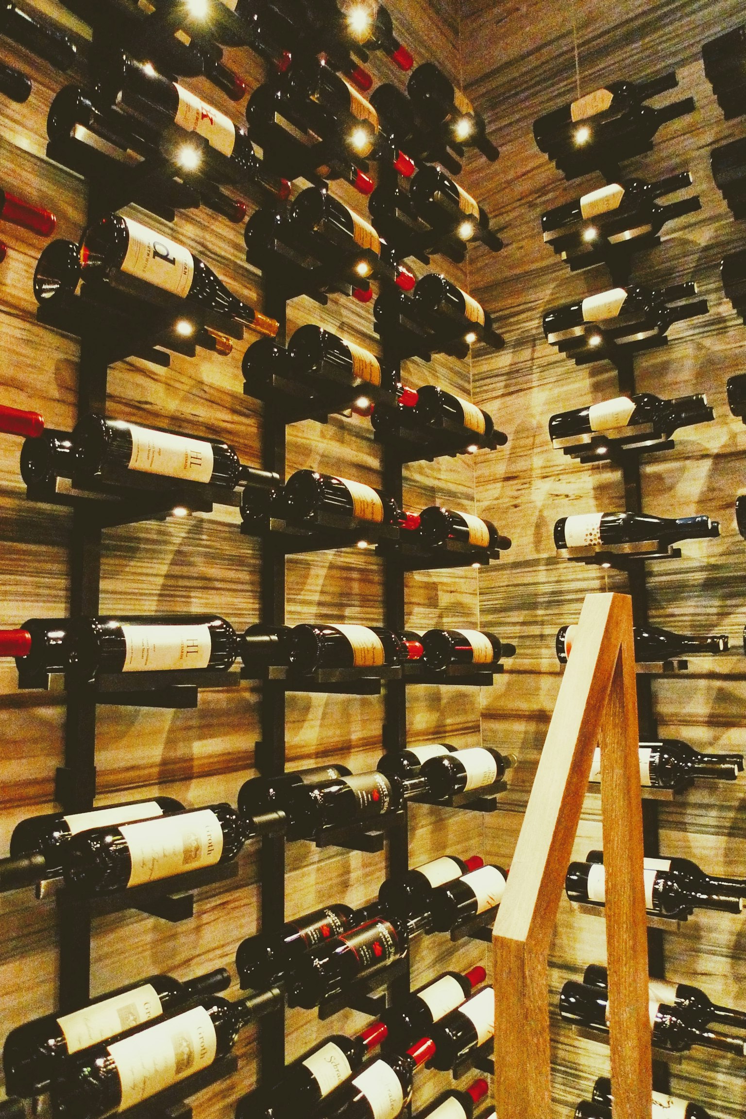 Interior of a wooden wine cabinet with neatly arranged wine bottles