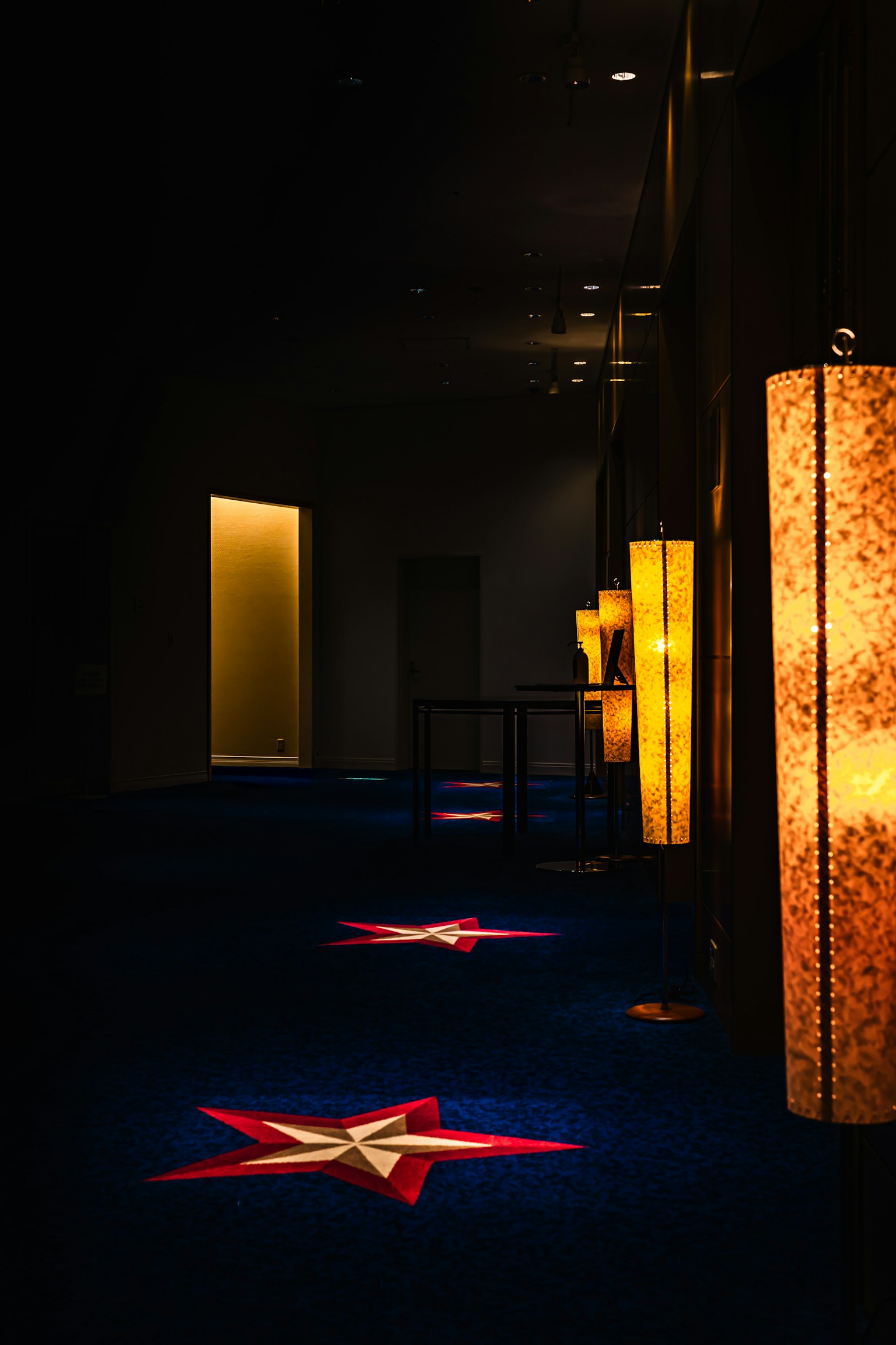 Corridoio buio con tappeto a motivo di stelle e lampade illuminate