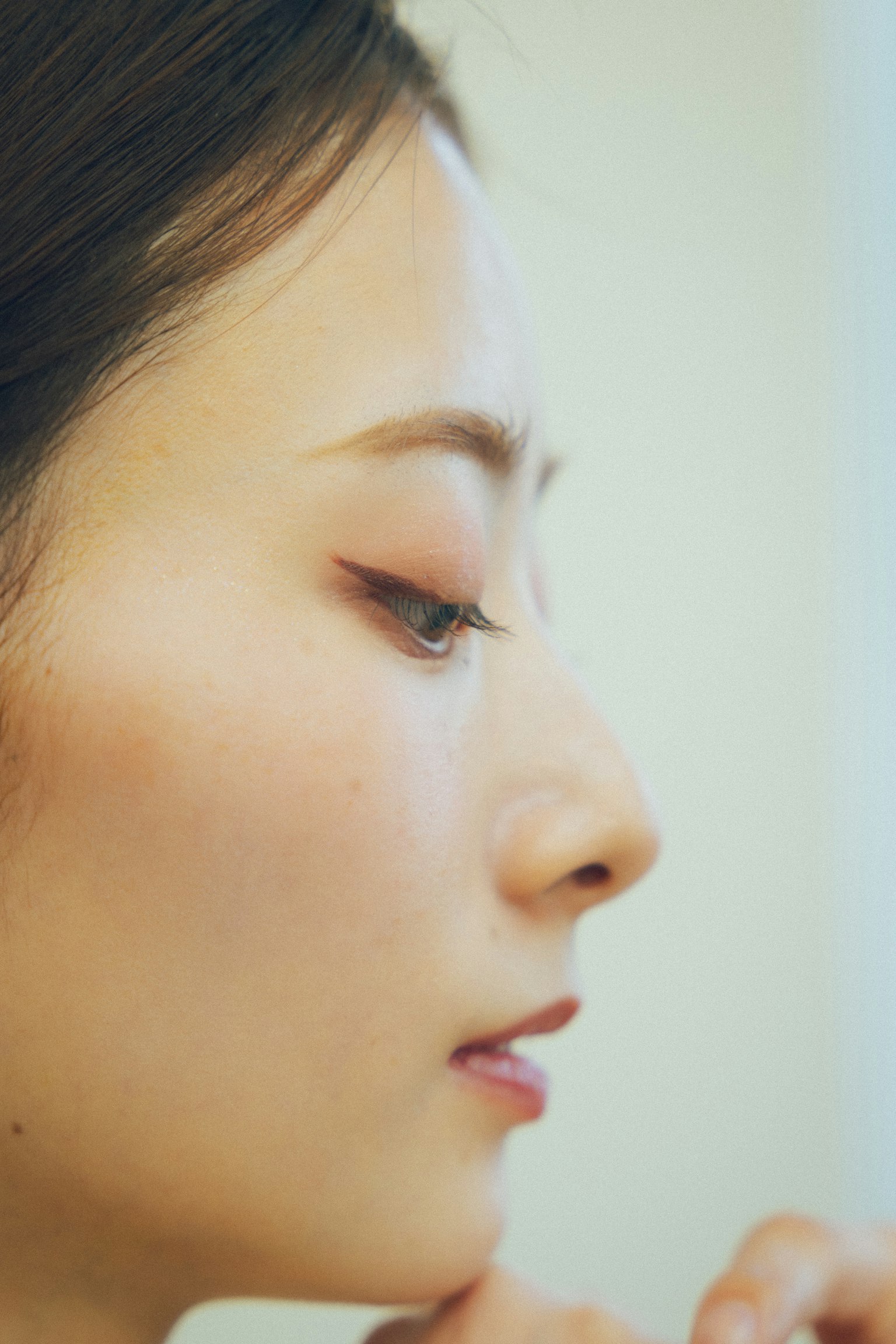 A beautifully captured profile of a woman featuring natural makeup and a soft expression
