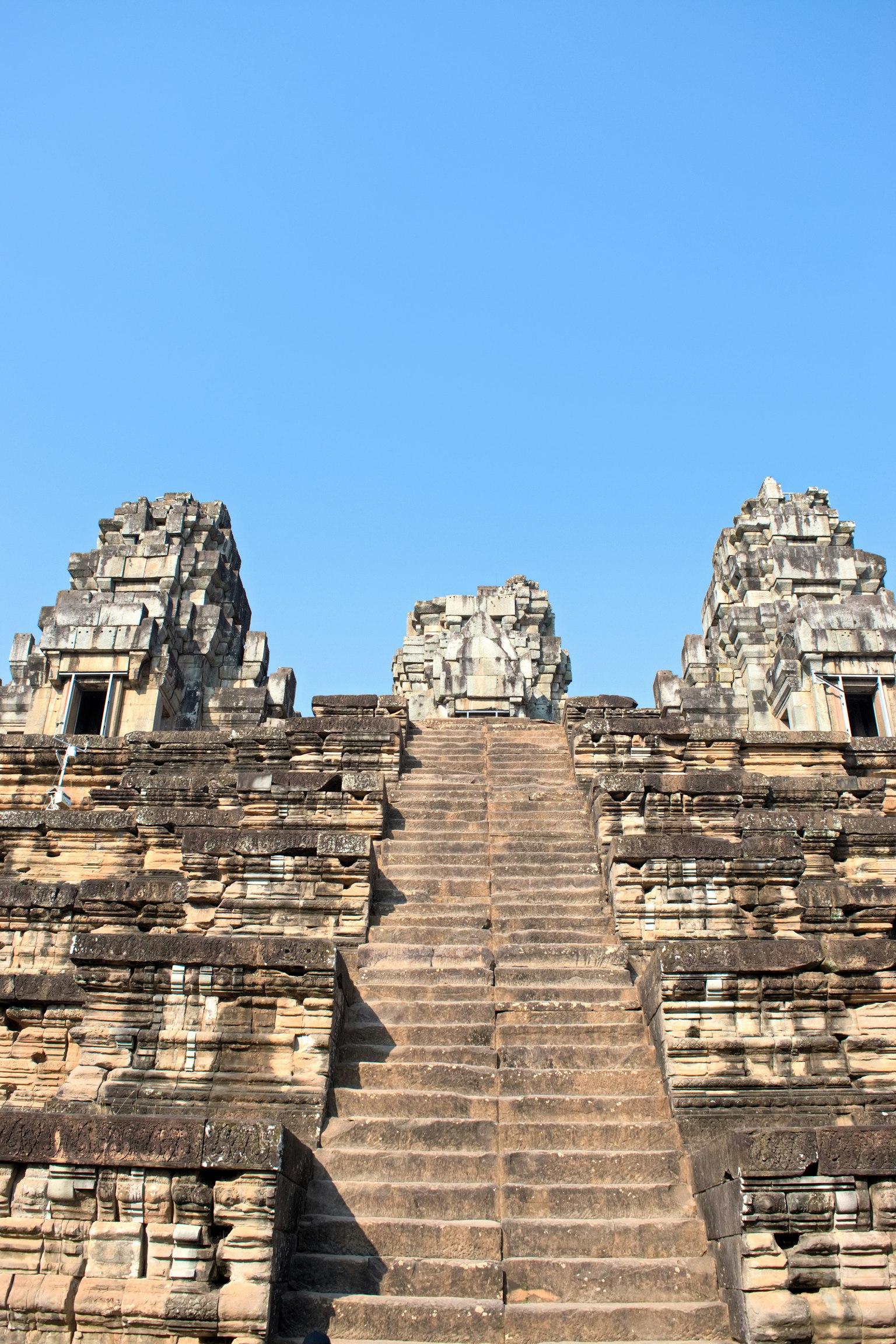 Scale di un tempio che conducono a torri di pietra sotto un cielo blu