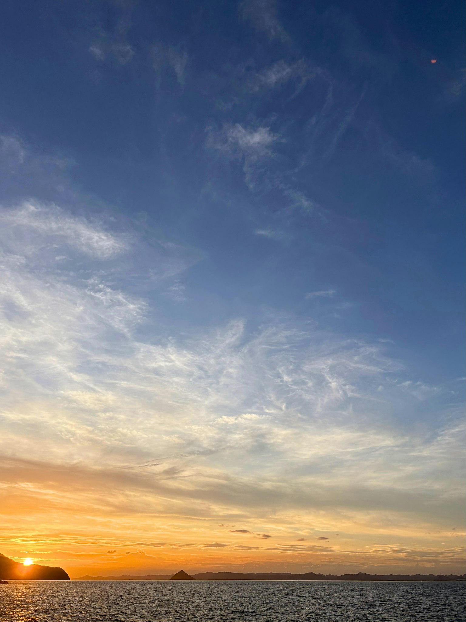 Bellissimo tramonto sull'oceano con cielo blu e nuvole arancioni