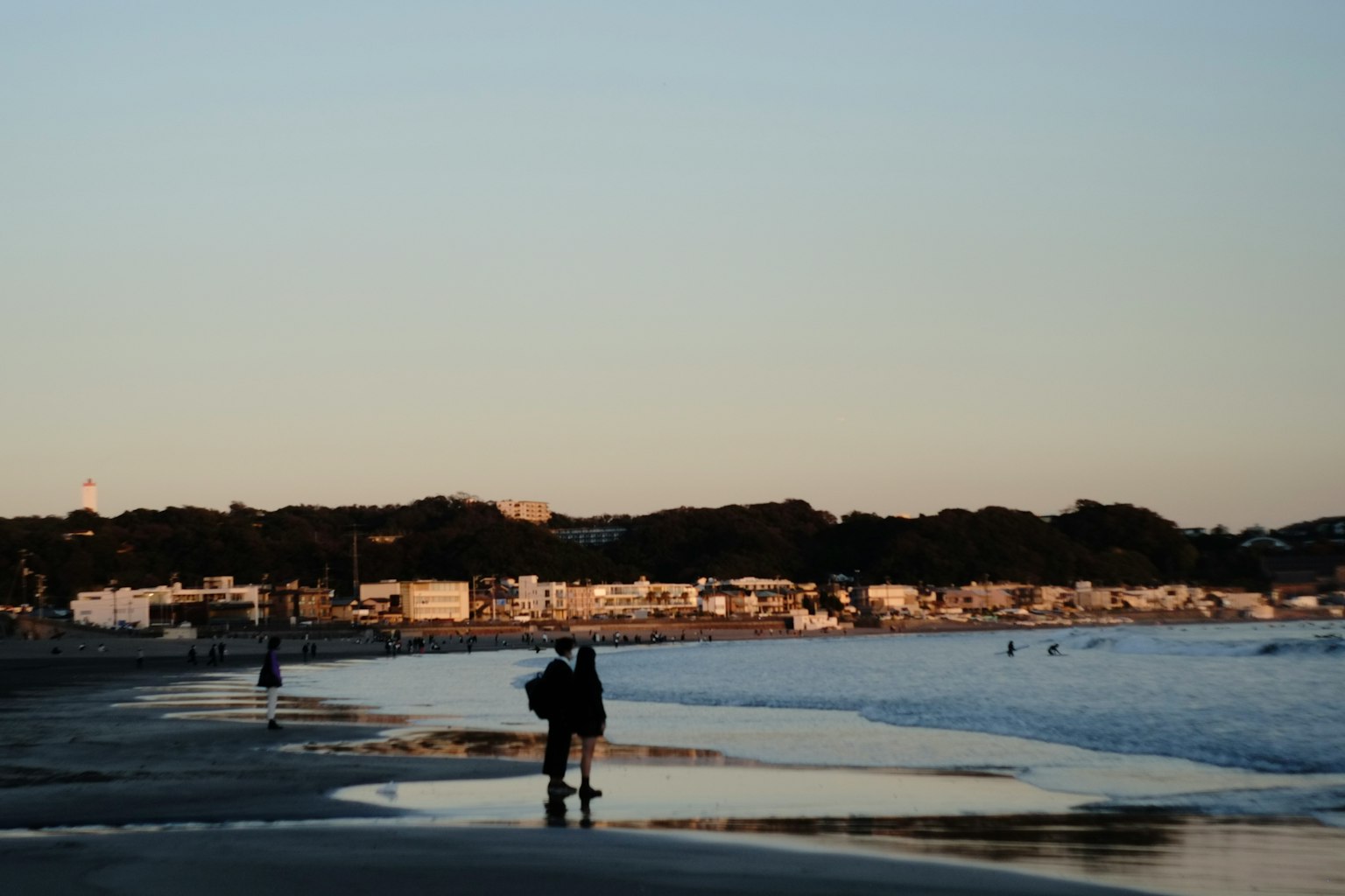Silhouette of a person standing on the beach at sunset