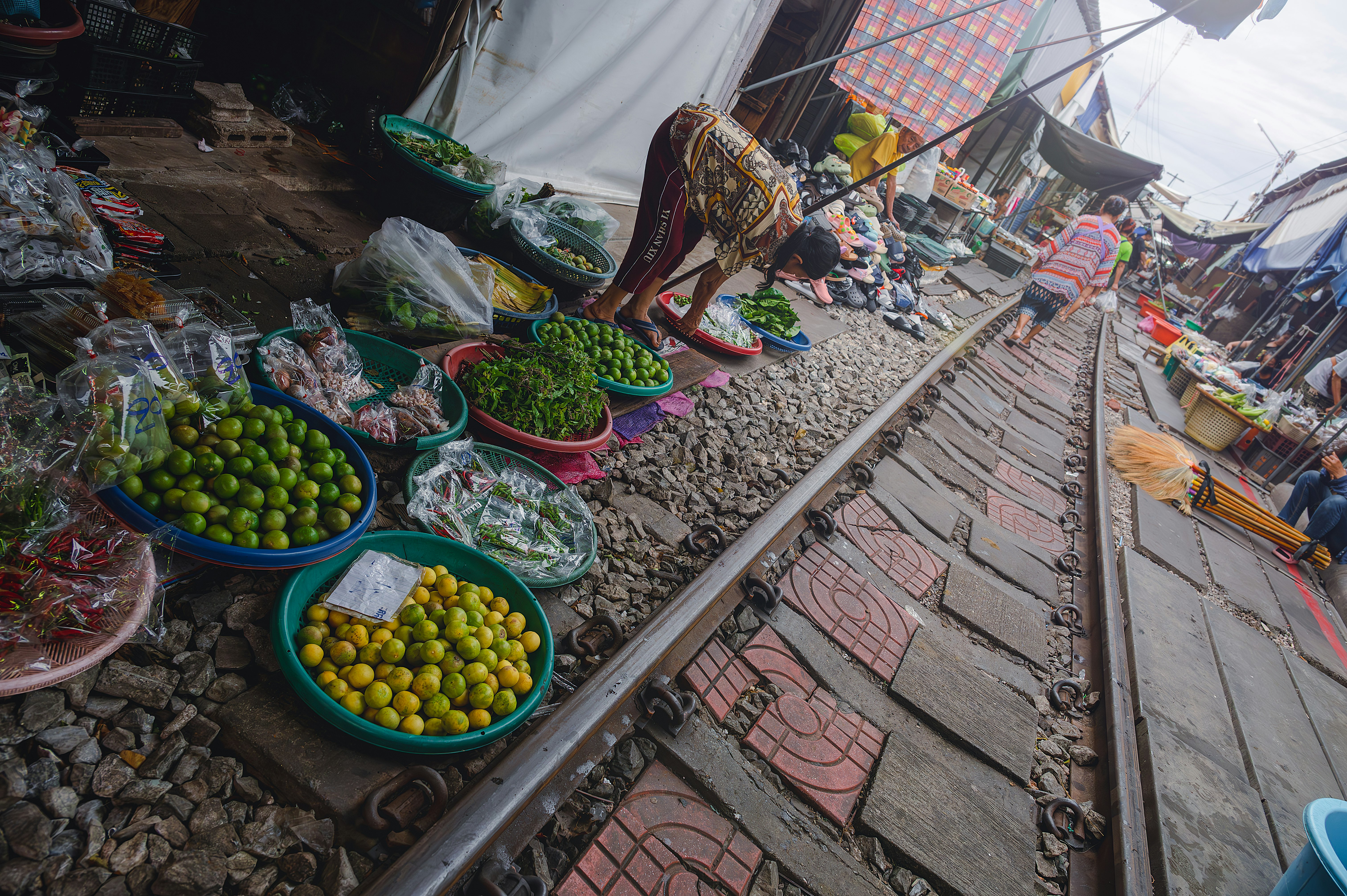 Maeklong Market scene with fruit stalls lined along the railway