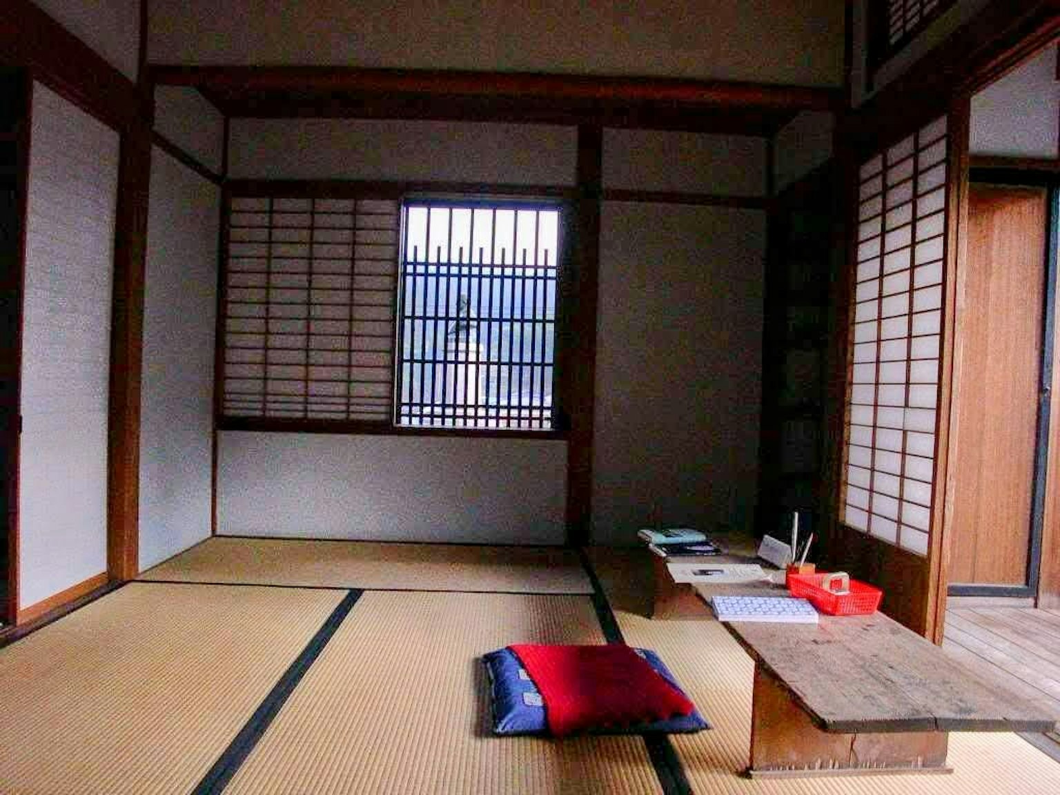 Interior ruangan Jepang tradisional dengan lantai tatami dan cahaya alami yang masuk melalui jendela