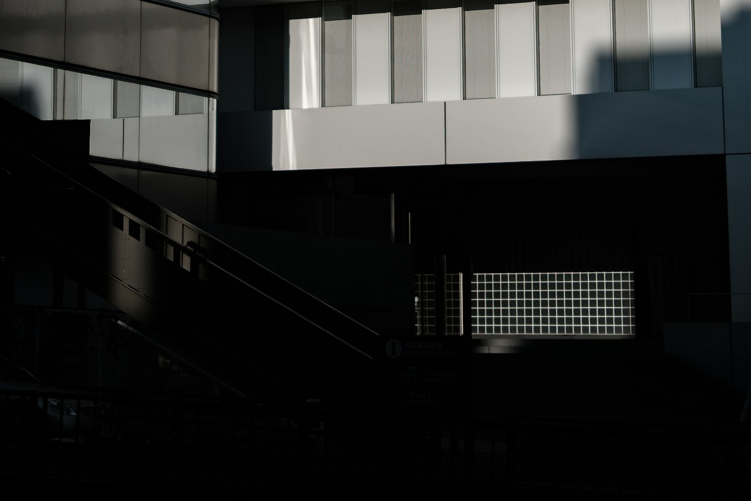 Kontrast zwischen moderner Gebäudefassade und Schatten