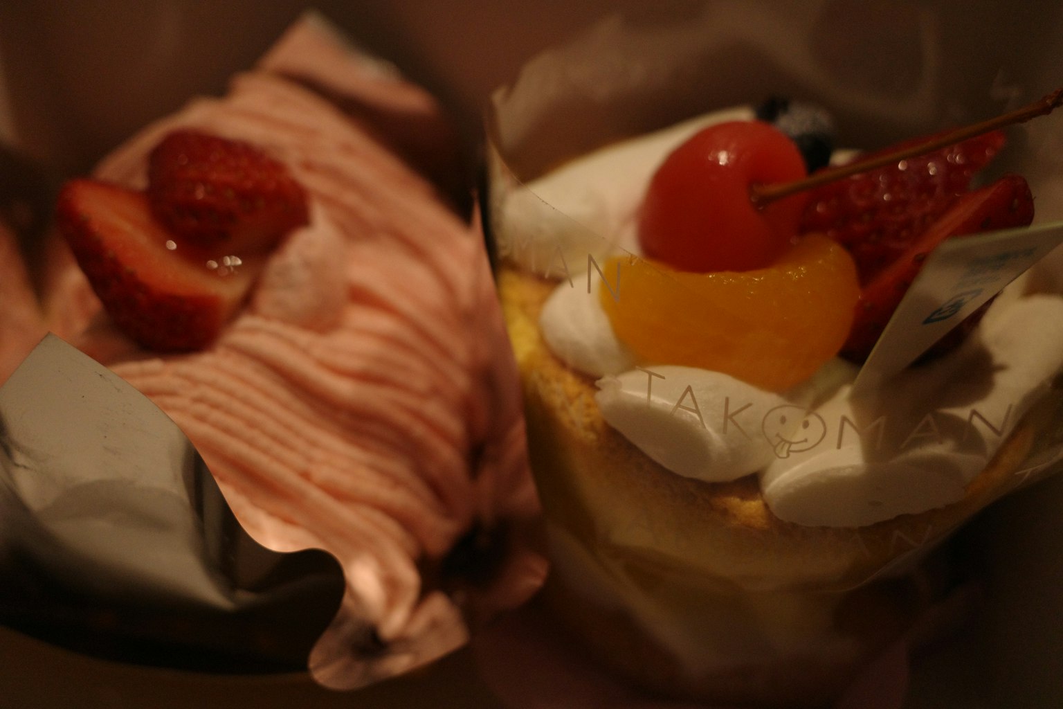Des tasses de dessert avec des garnitures de fraises et de fruits sont exposées