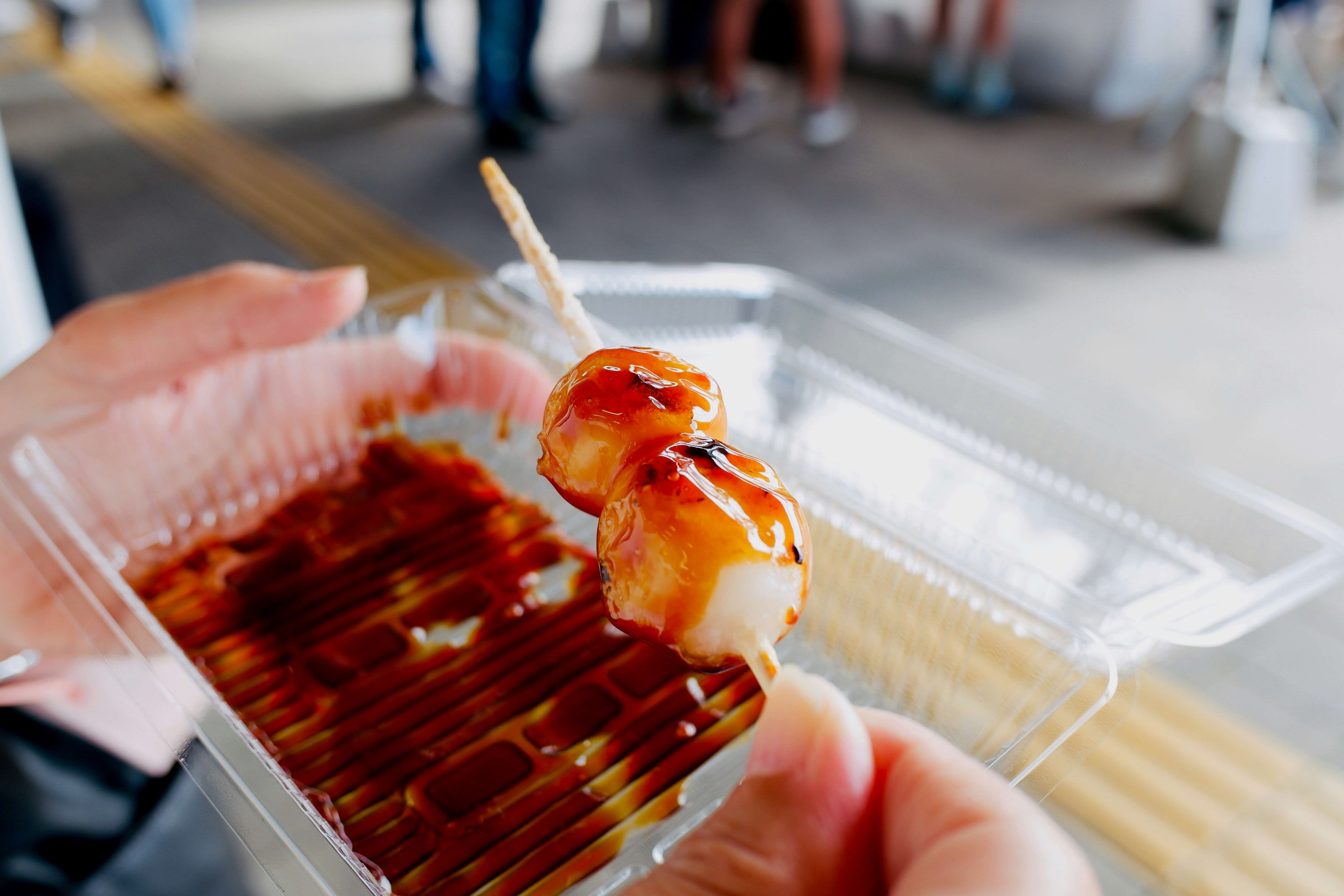 persona che tiene uno spiedino sopra un vassoio di street food grigliata