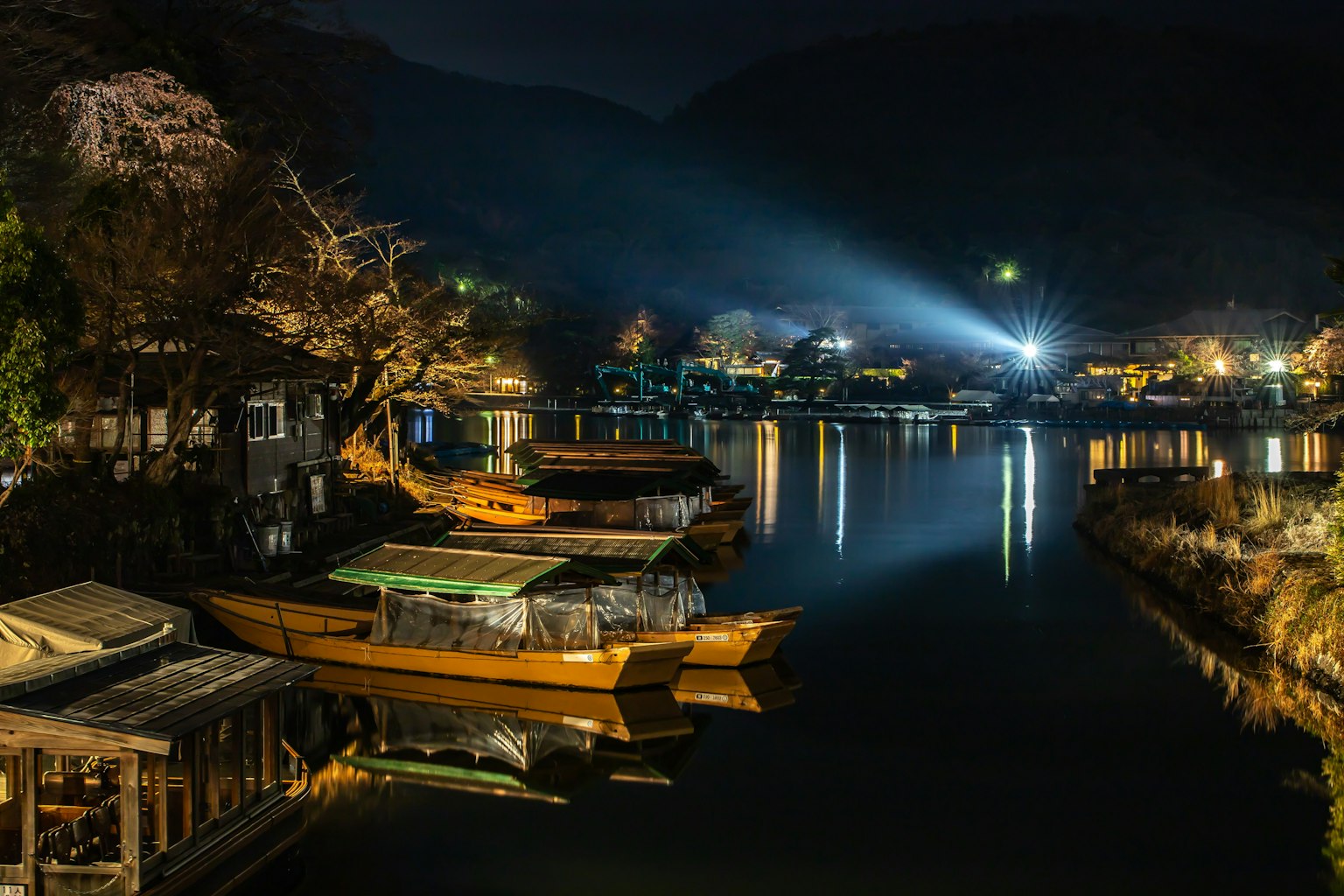 寧靜的夜晚場景，小船在河上，周圍建築物被照亮