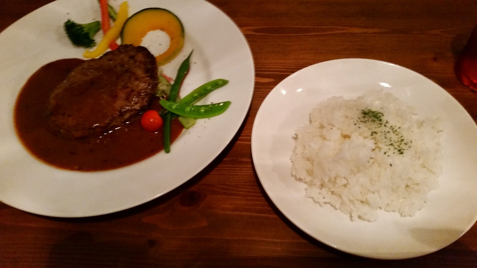 Delicious hamburger steak served with white rice and colorful vegetables