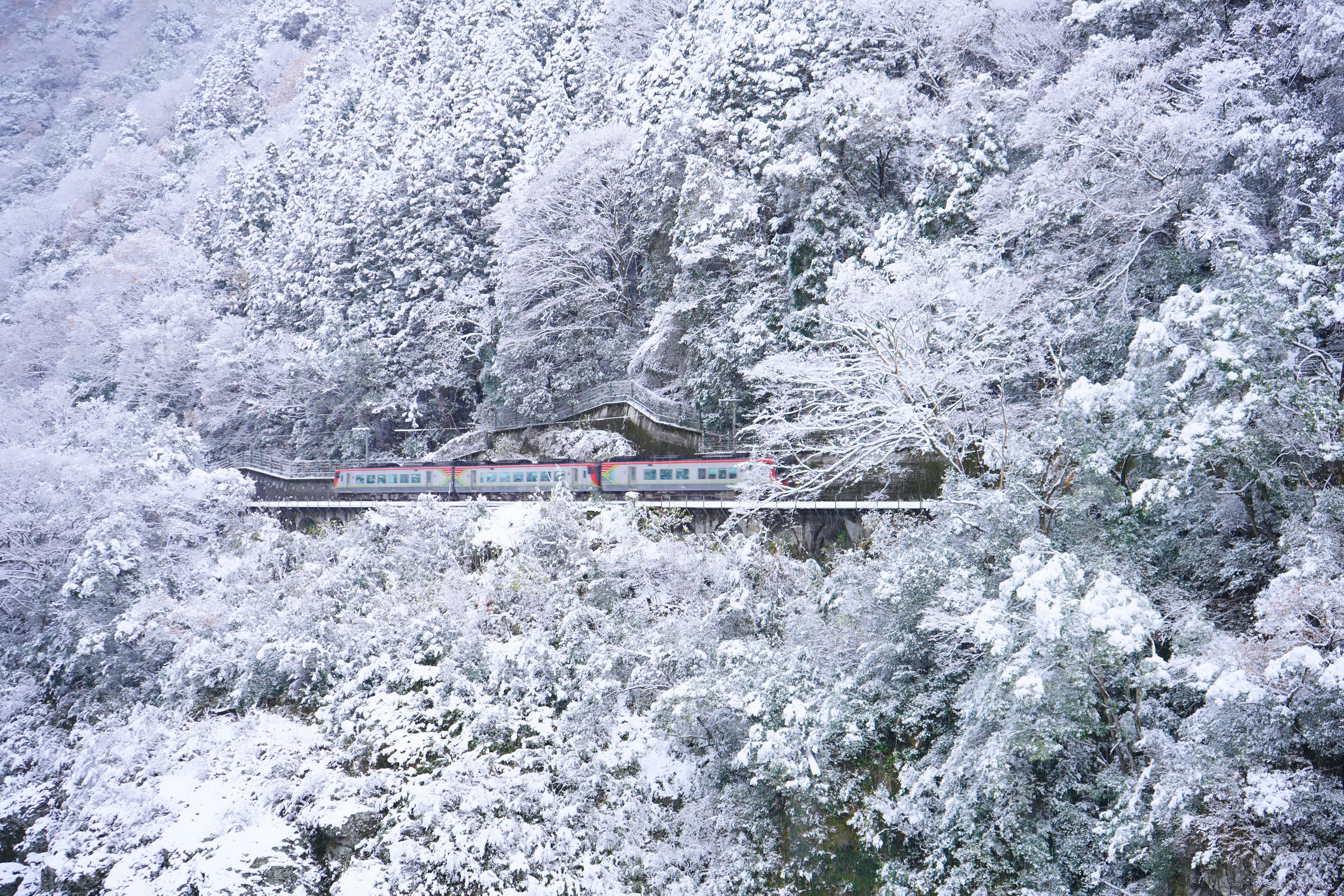 雪に覆われた山々の中にある赤い屋根の家