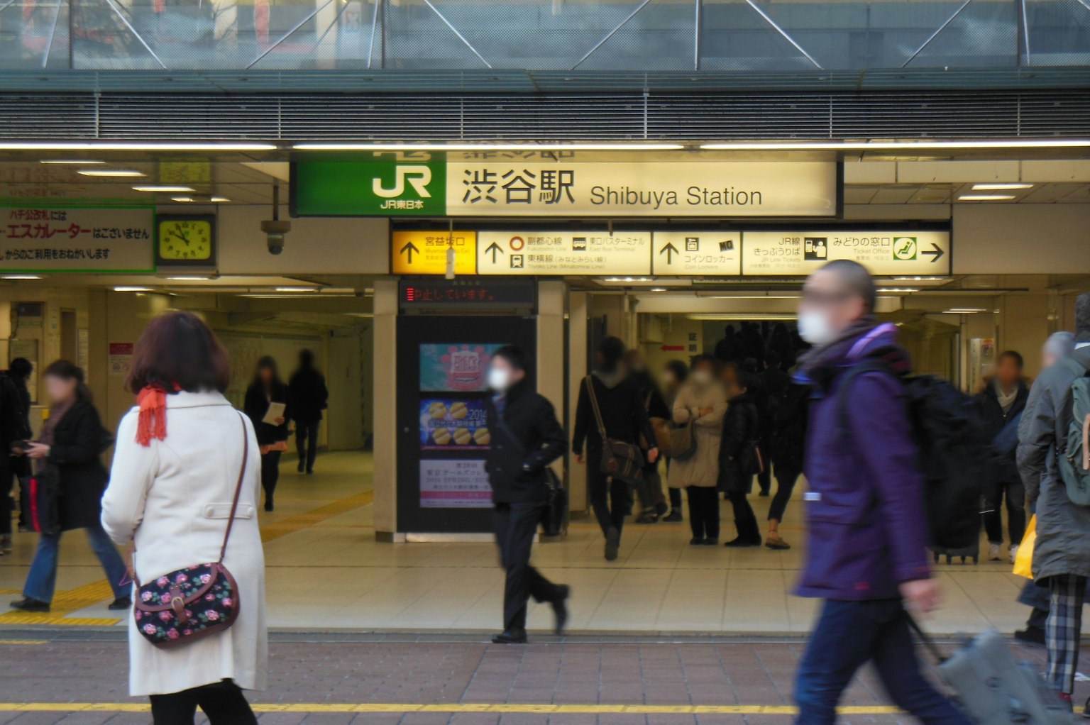 Belebte Szene am Eingang des Shibuya Bahnhofs mit vorbeigehenden Menschen