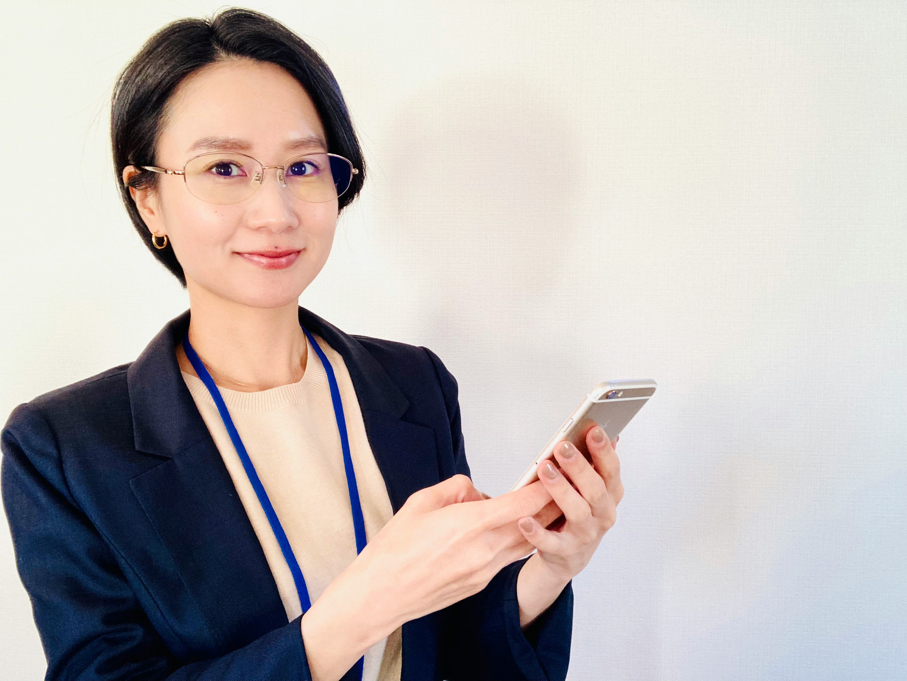 Nữ nhân viên y tế cầm điện thoại thông minh trên nền trắng