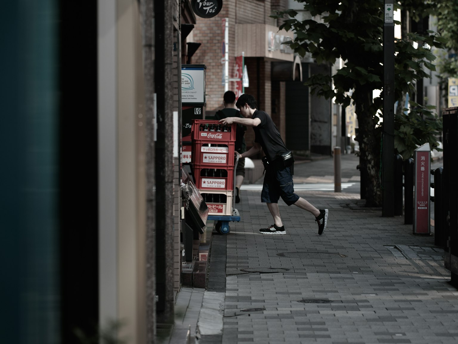 一個男人靠在城市街道上的自動販賣機旁