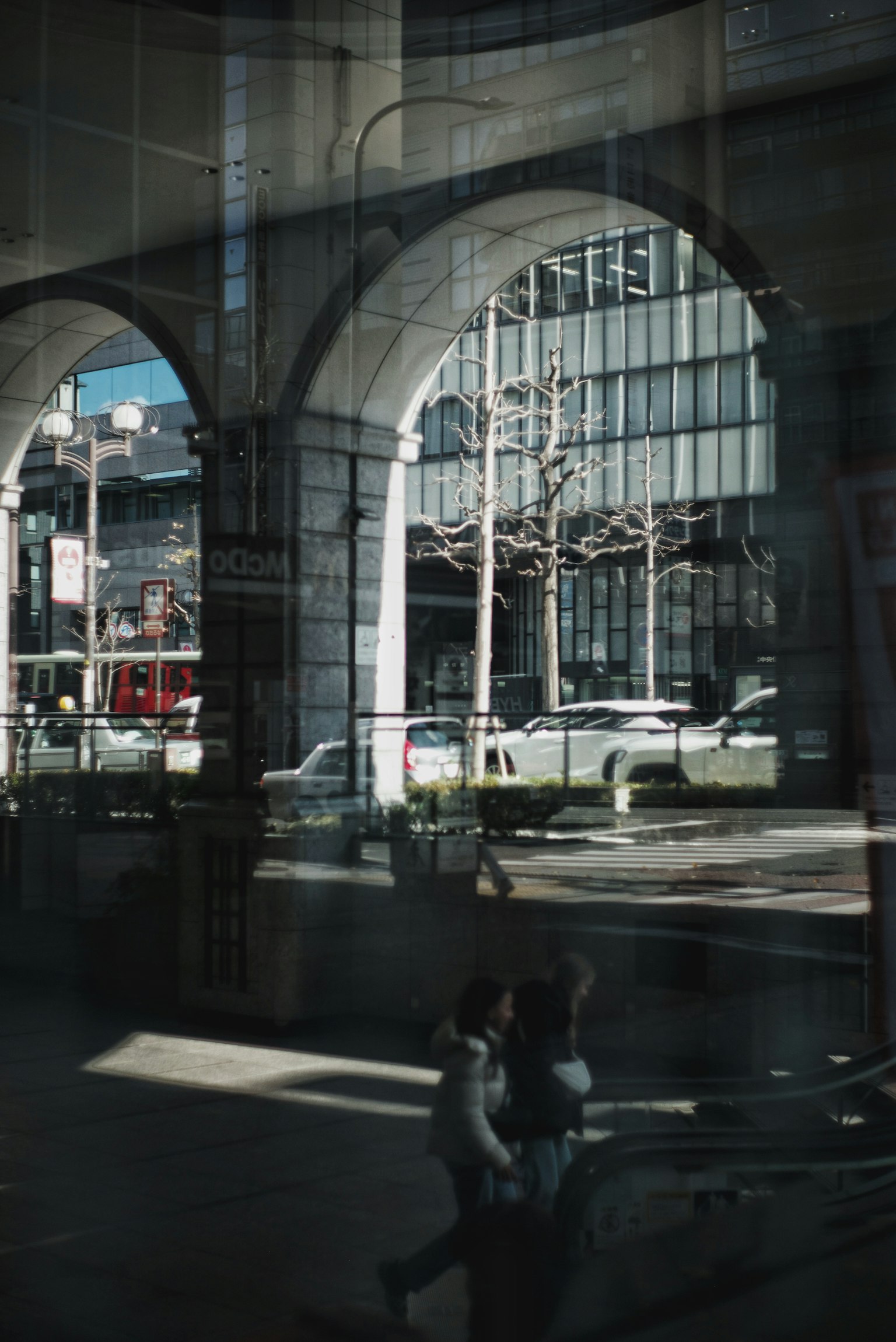 Vista del paesaggio urbano attraverso finestre ad arco con riflessi di persone