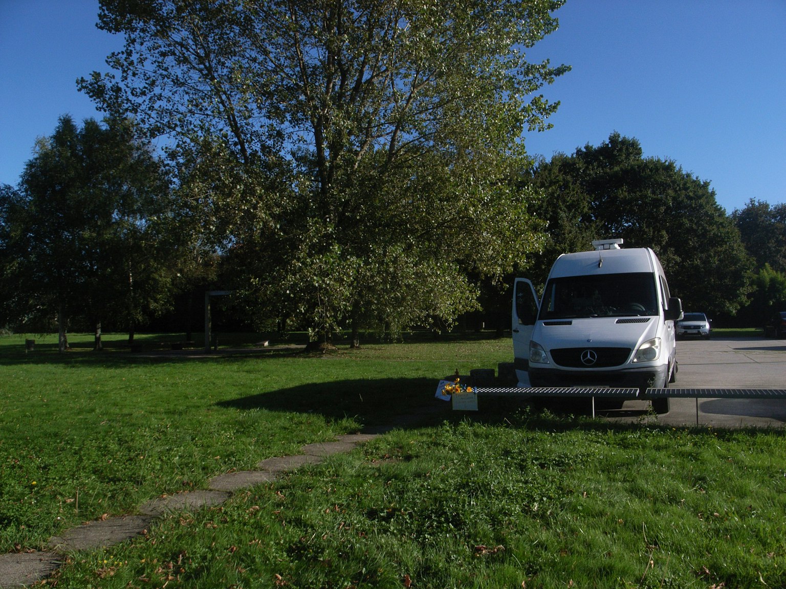 Ein Wohnmobil, das auf grünem Gras unter einem blauen Himmel parkt